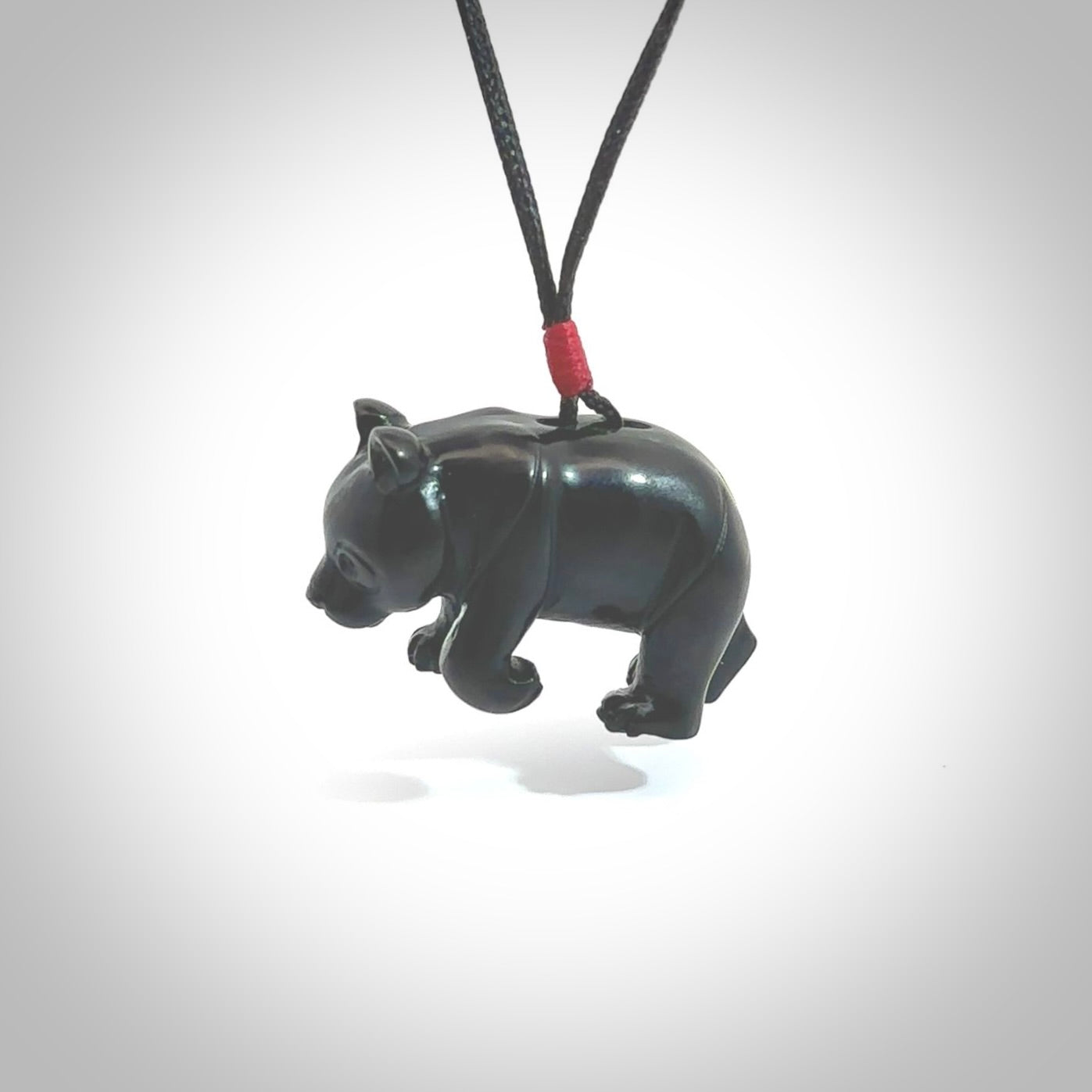 This picture shows a pendant that we designed in black jade. It is a little black bear that has a walking stance and is carved in detail. A really attractive and eye-catching piece of handmade jewellery. The cord is hand plaited braid in black and pale honey and the length can be adjusted.