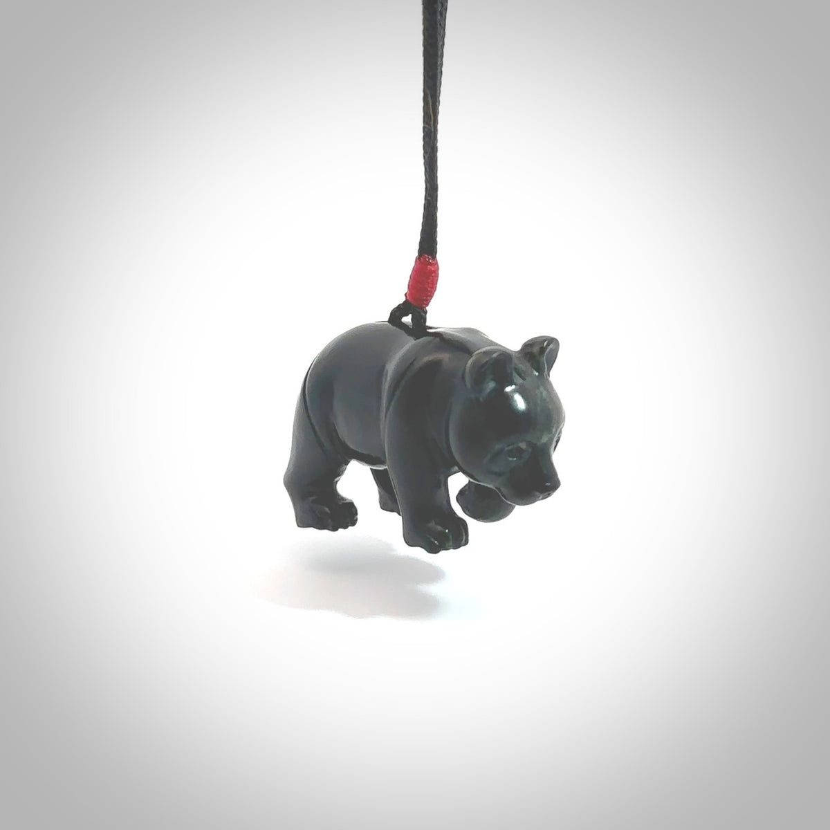 This picture shows a pendant that we designed in black jade. It is a little black bear that has a walking stance and is carved in detail. A really attractive and eye-catching piece of handmade jewellery. The cord is hand plaited braid in black and pale honey and the length can be adjusted.