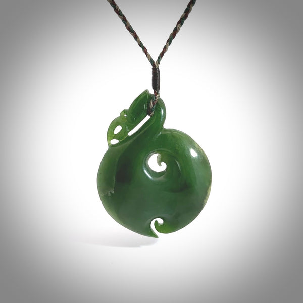 Hand carved medium sized New Zealand jade manaia with koru pendant. Made for NZ Pacific by Ross Crump. We will ship this to you with and express courier service. This is a one-off piece and is collectable. A gorgeous pendant!