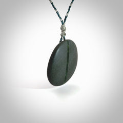 Greywacke stone pendant with New Zealand Jade Pounamu insert. Hand carved by Rhys Hall for NZ Pacific. Handmade jewellery for sale online. Delivered to you with express courier in one of our kete pouches.