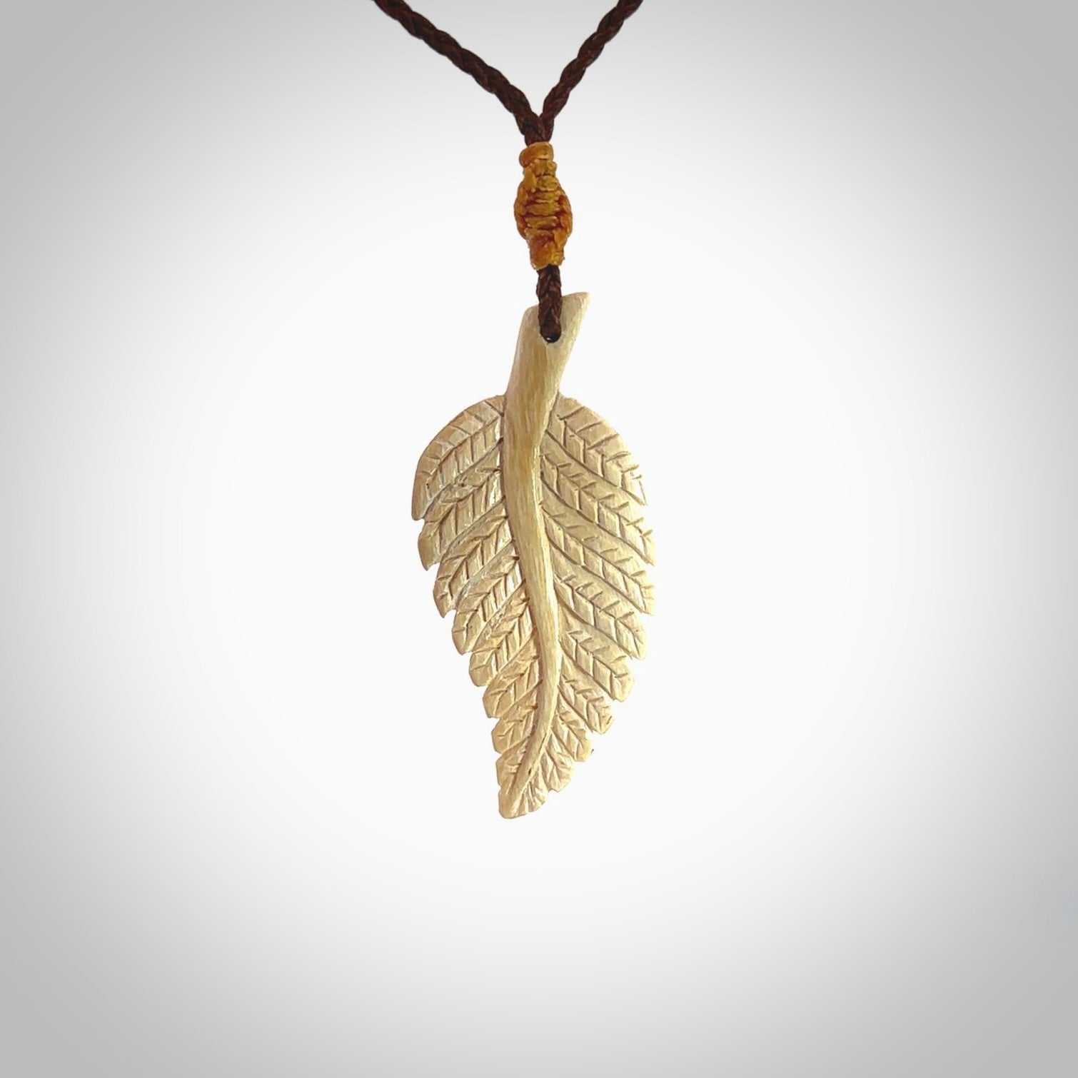 Hand carved woolly mammoth tusk fern pendant. Made in New Zealand. Unique hand made gifts from NZ Pacific. Hand carved fern necklace from ancient woolly mammoth tusk.