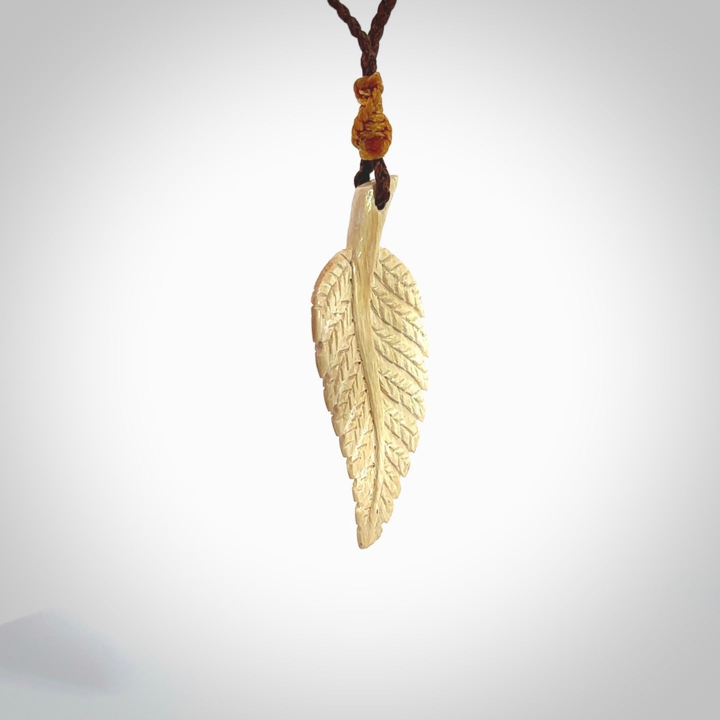 Hand carved woolly mammoth tusk fern pendant. Made in New Zealand. Unique hand made gifts from NZ Pacific. Hand carved fern necklace from ancient woolly mammoth tusk.