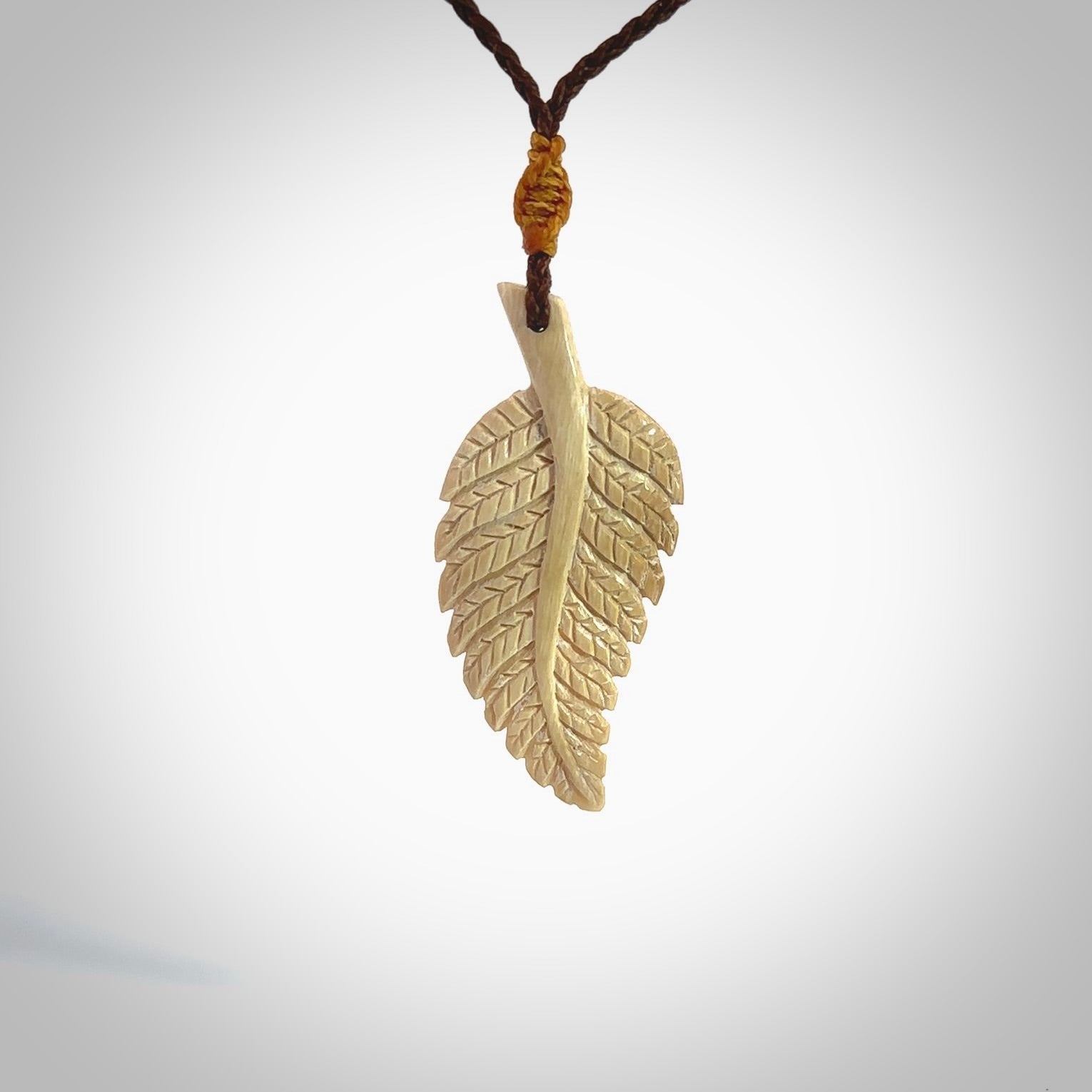 Hand carved woolly mammoth tusk fern pendant. Made in New Zealand. Unique hand made gifts from NZ Pacific. Hand carved fern necklace from ancient woolly mammoth tusk.