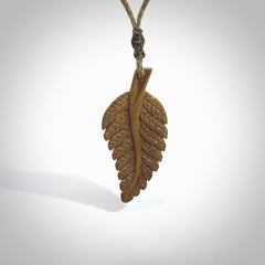 Hand carved woolly mammoth tusk fern pendant. Made in New Zealand. Unique hand made gifts from NZ Pacific. Hand carved fern necklace from ancient woolly mammoth tusk.