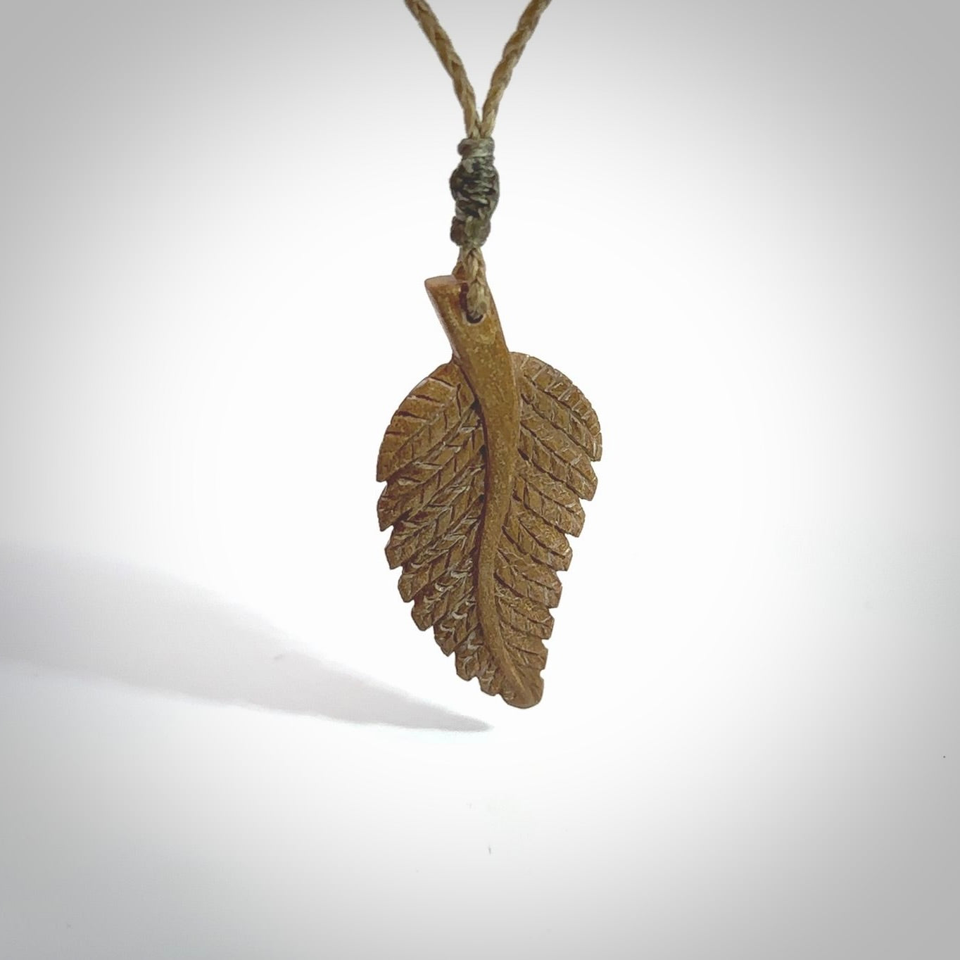 Hand carved woolly mammoth tusk fern pendant. Made in New Zealand. Unique hand made gifts from NZ Pacific. Hand carved fern necklace from ancient woolly mammoth tusk.