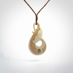 Hand carved Bone Whale Tail pendant with Paua shell inlay by Andrew Doughty. Whale tail pendant by Andrew Doughty with engraving in it. Beautiful unisex necklace hand carved in New Zealand, delivered in a woven kete pouch. Provided with an adjustable brown cord.