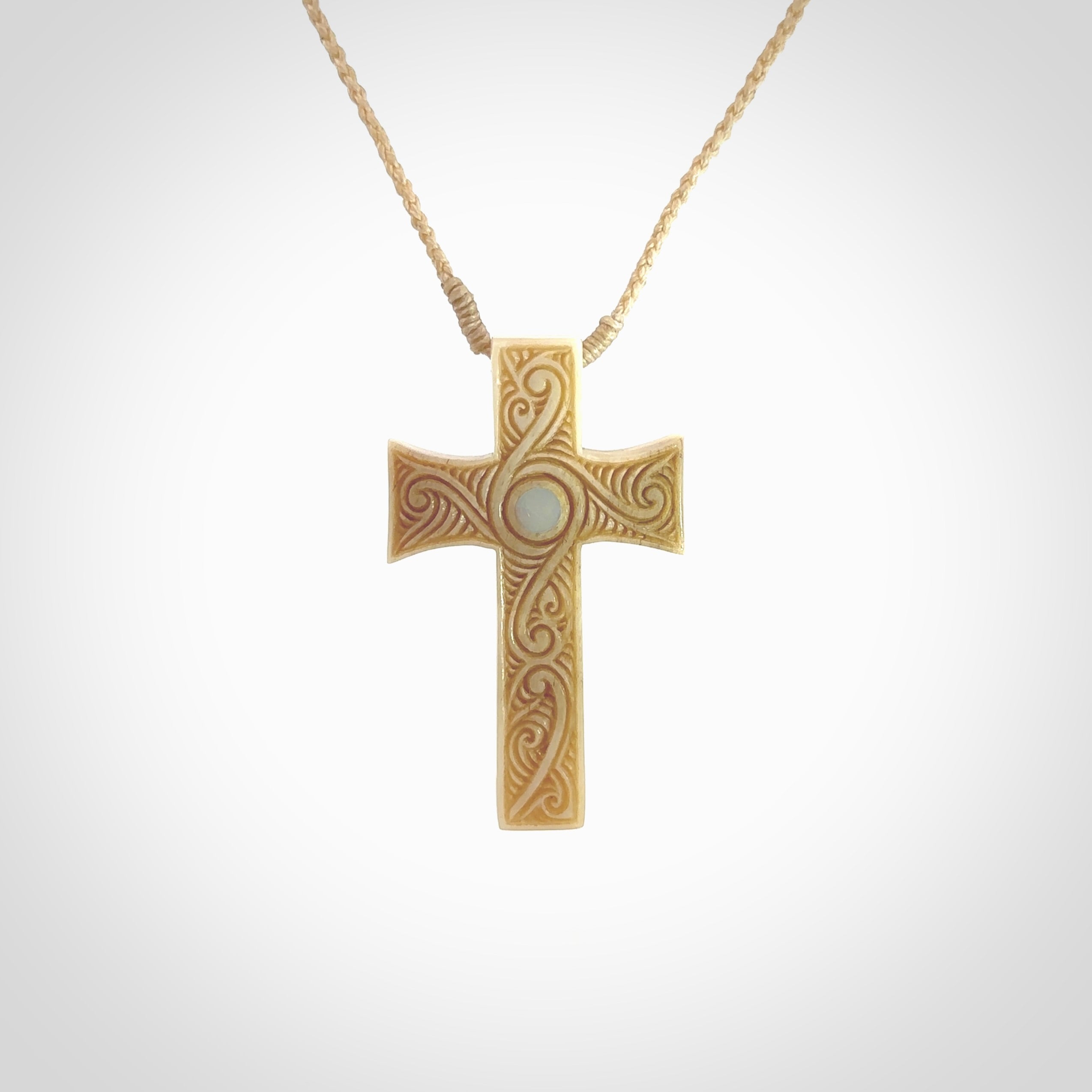 Hand carved Bone religious cross pendant by Andrew Doughty. Cross pendant with Opal inlay by Andrew Doughty with engraving in it. Beautiful unisex necklace hand carved in New Zealand, delivered in a woven kete pouch. Provided with an adjustable beige cord.