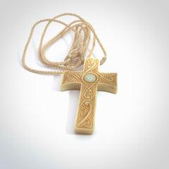 Hand carved Bone religious cross pendant by Andrew Doughty. Cross pendant with Opal inlay by Andrew Doughty with engraving in it. Beautiful unisex necklace hand carved in New Zealand, delivered in a woven kete pouch. Provided with an adjustable beige cord.