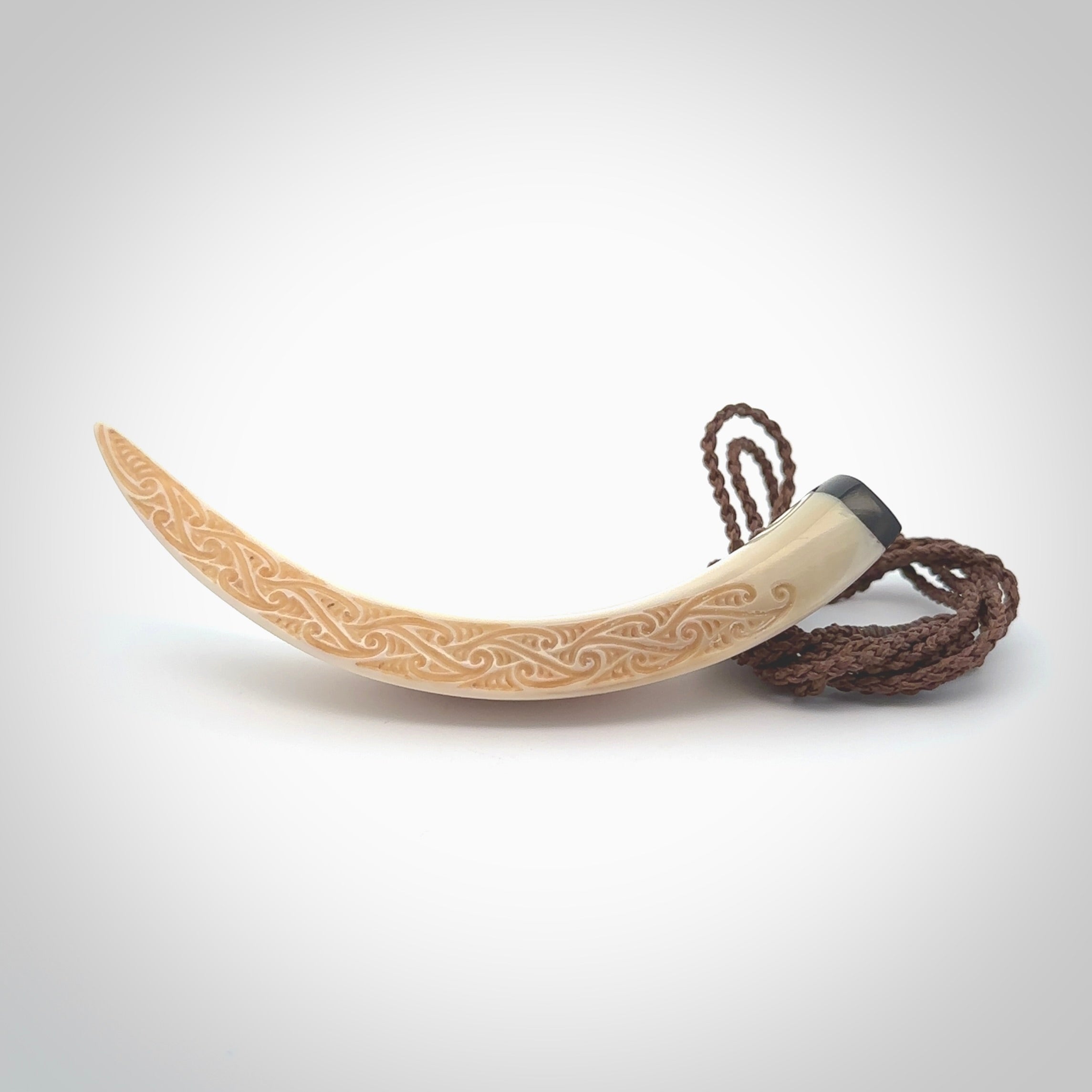 Hand carved Boars Tusk pendant with Buffalo horn, Mother of Pearl and Brass. Engraved large boars tusk pendant. Unisex necklace hand carved by Andrew Doughty here in New Zealand. Unique art to wear. Delivered with an adjustable brown cord.