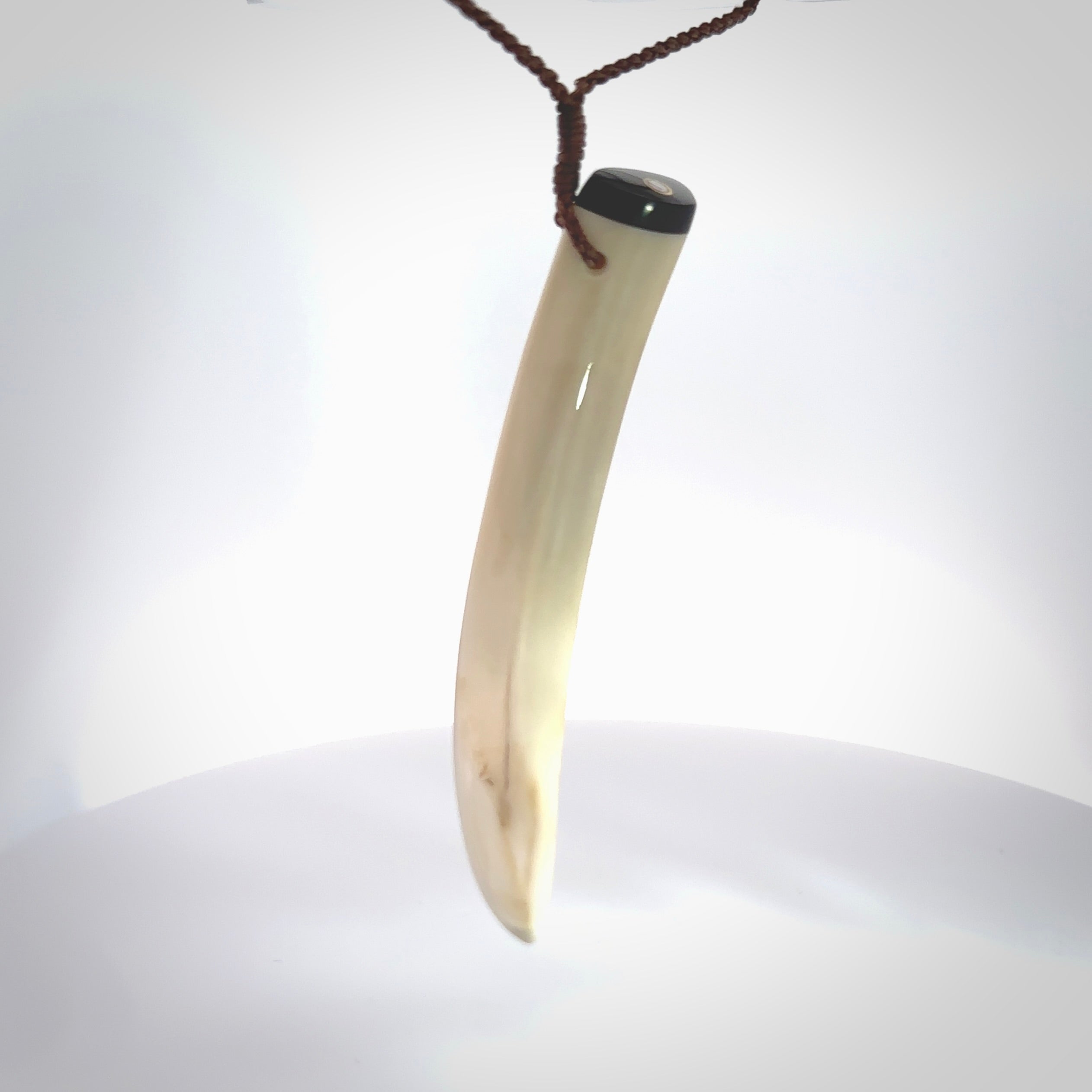 Hand carved Boars Tusk pendant with Buffalo horn, Mother of Pearl and Brass. Engraved large boars tusk pendant. Unisex necklace hand carved by Andrew Doughty here in New Zealand. Unique art to wear. Delivered with an adjustable brown cord.