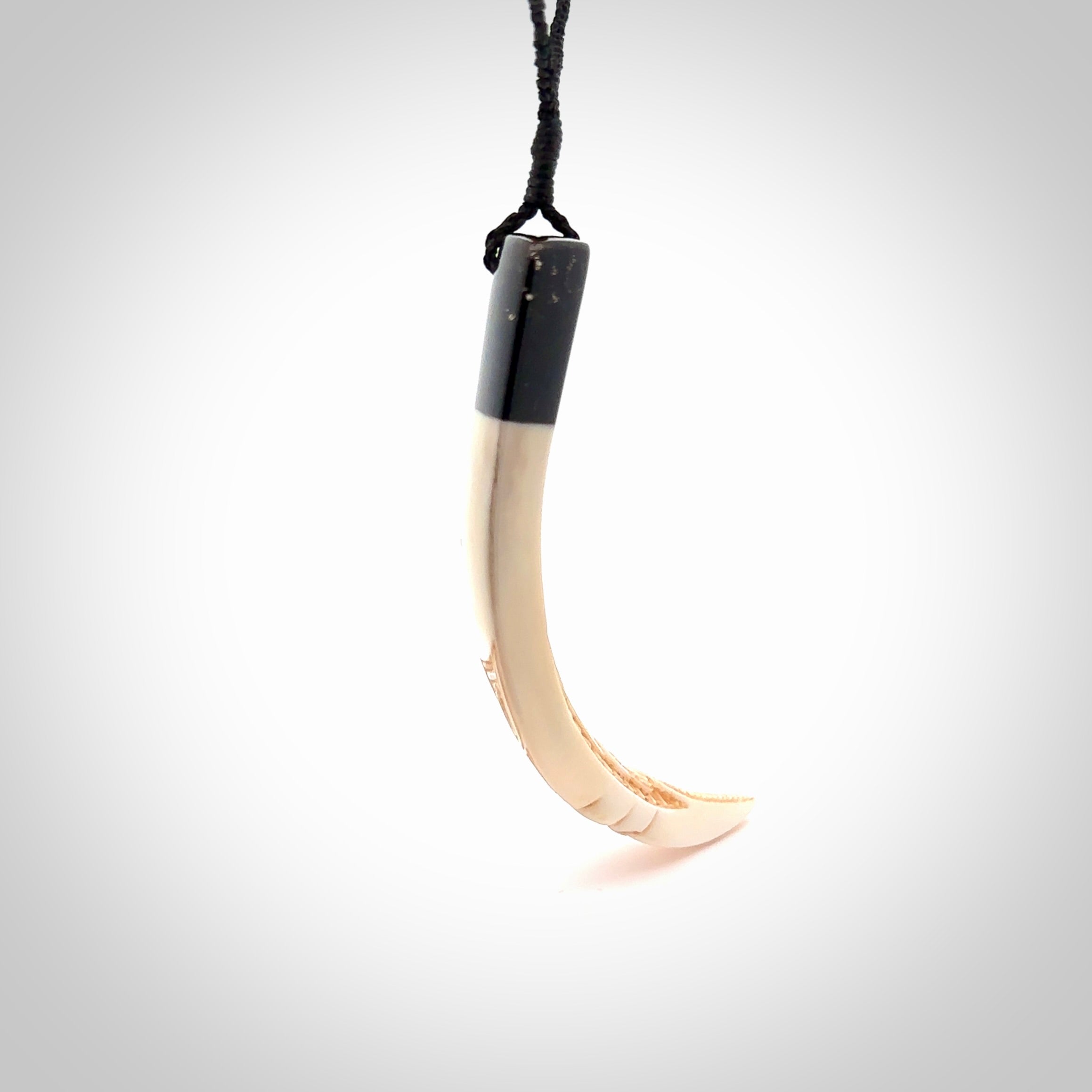 Hand carved Boars Tusk pendant with Buffalo horn and Paua Shell. Engraved large boars tusk pendant. Unisex necklace hand carved by Andrew Doughty here in New Zealand. Unique art to wear. Delivered with an adjustable black cord.