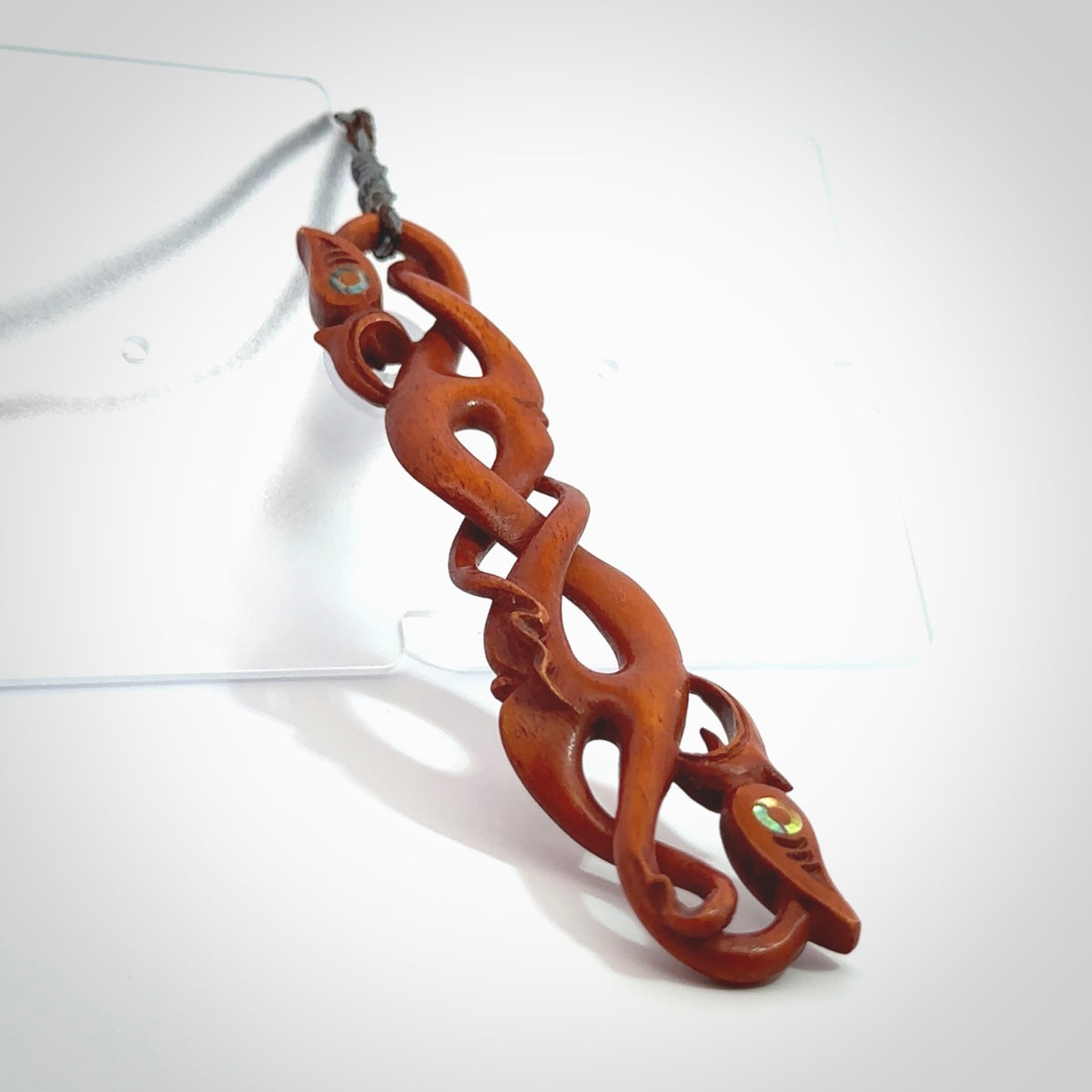 This necklace is carved from cow bone and stained with a homemade tea dye. It is a unique piece of wearable art that is sure to catch the eye. The shape is a complex twist form and has been beautifully hand carved by bone carver Yuri Terenyi.