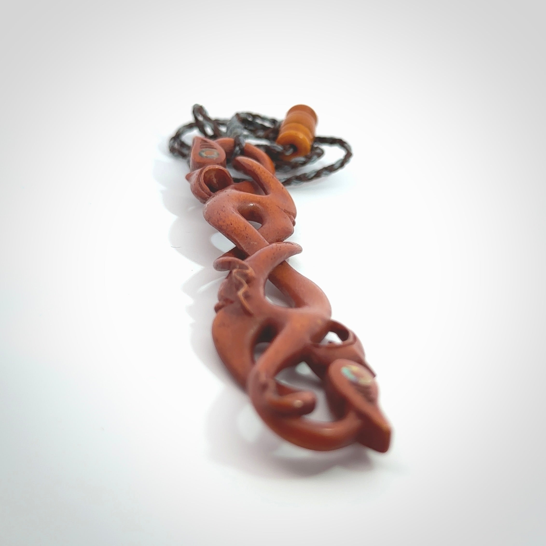 This necklace is carved from cow bone and stained with a homemade tea dye. It is a unique piece of wearable art that is sure to catch the eye. The shape is a complex twist form and has been beautifully hand carved by bone carver Yuri Terenyi.