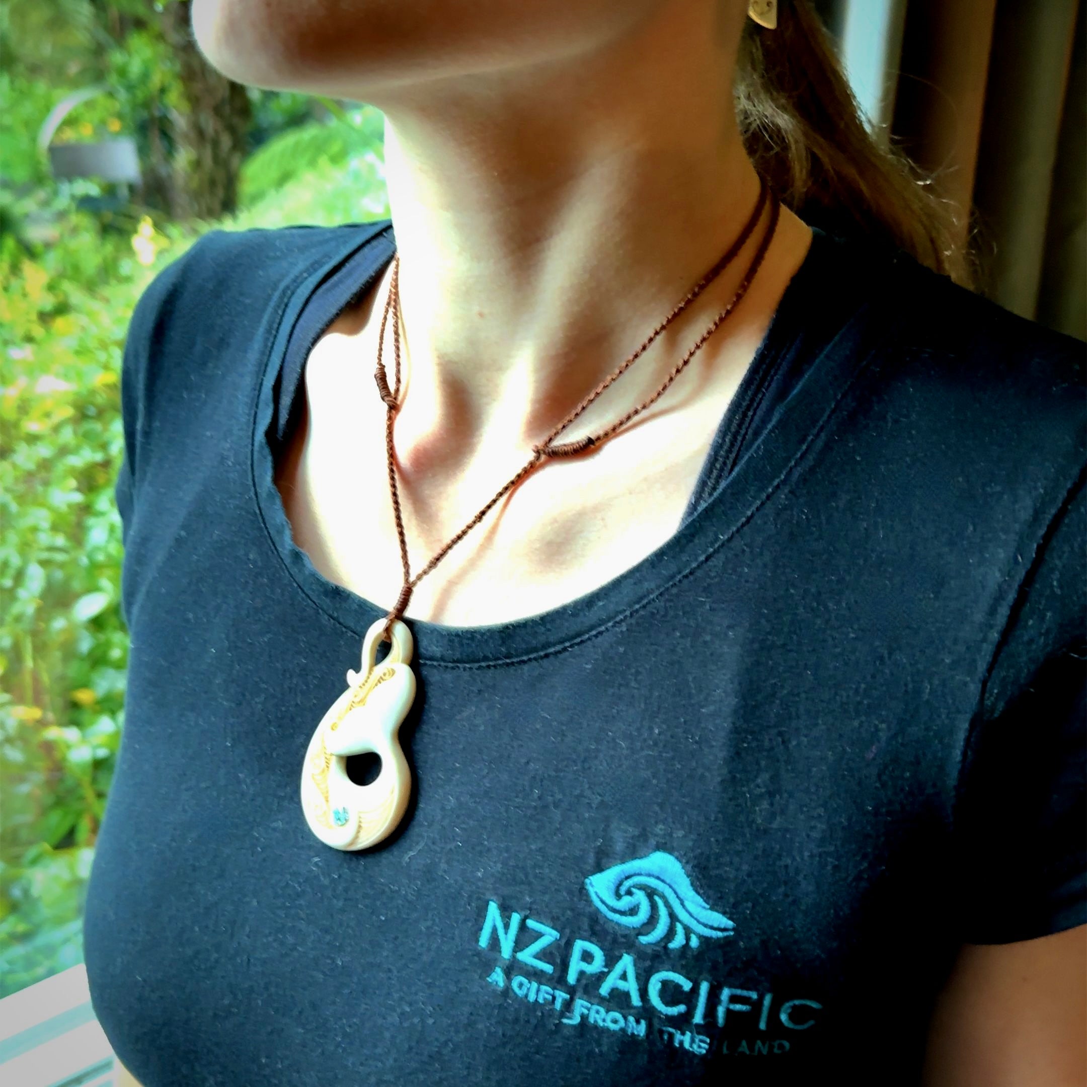 Hand carved Bone Whale Tail pendant with Paua shell inlay by Andrew Doughty. Whale tail pendant by Andrew Doughty with engraving in it. Beautiful unisex necklace hand carved in New Zealand, delivered in a woven kete pouch. Provided with an adjustable brown cord.