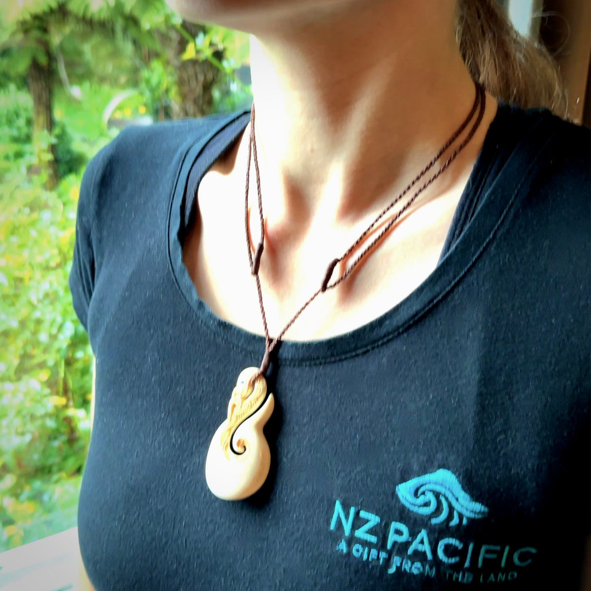 Hand carved bone manaia with matau, hook pendant. Hand made by Andrew opughty, delivered with an adjustable brown cord. Manaia with Paua shell eyes and engraving. One only necklace.