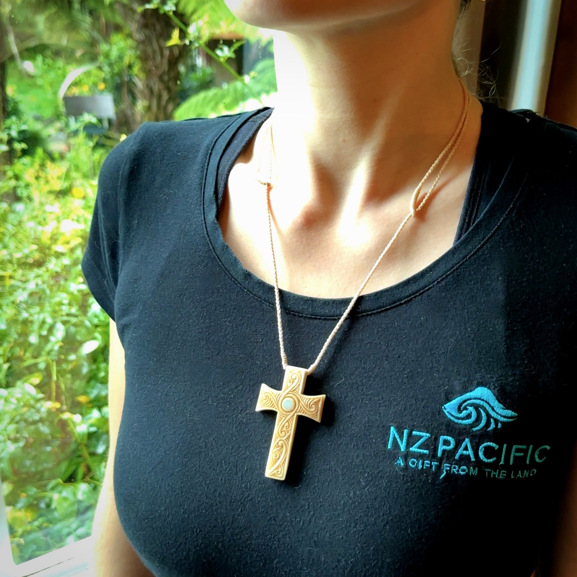 Hand carved Bone religious cross pendant by Andrew Doughty. Cross pendant with Opal inlay by Andrew Doughty with engraving in it. Beautiful unisex necklace hand carved in New Zealand, delivered in a woven kete pouch. Provided with an adjustable beige cord.