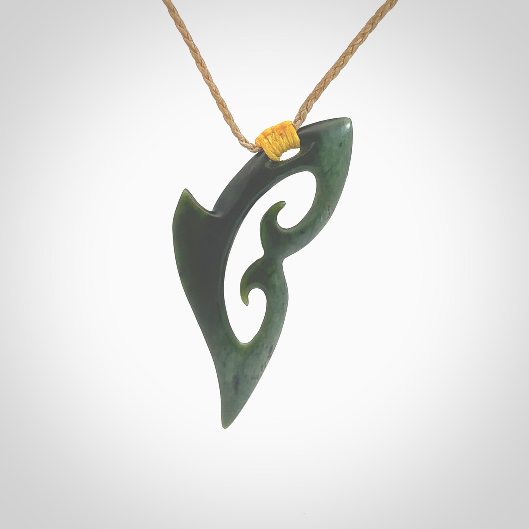 This photo shows a koru pendant carved from New Zealand Jade. The artist, Shaun Gardiner, has carved this beautifully. We provide this piece with an adjustable kalahari cord. This is a fantastic work of art, we have one only.