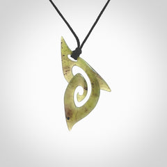 This photo shows a koru pendant carved from New Zealand Jade. The artist, Shaun Gardiner, has carved this beautifully. We provide this piece with an adjustable black cord. This is a fantastic work of art, we have one only.