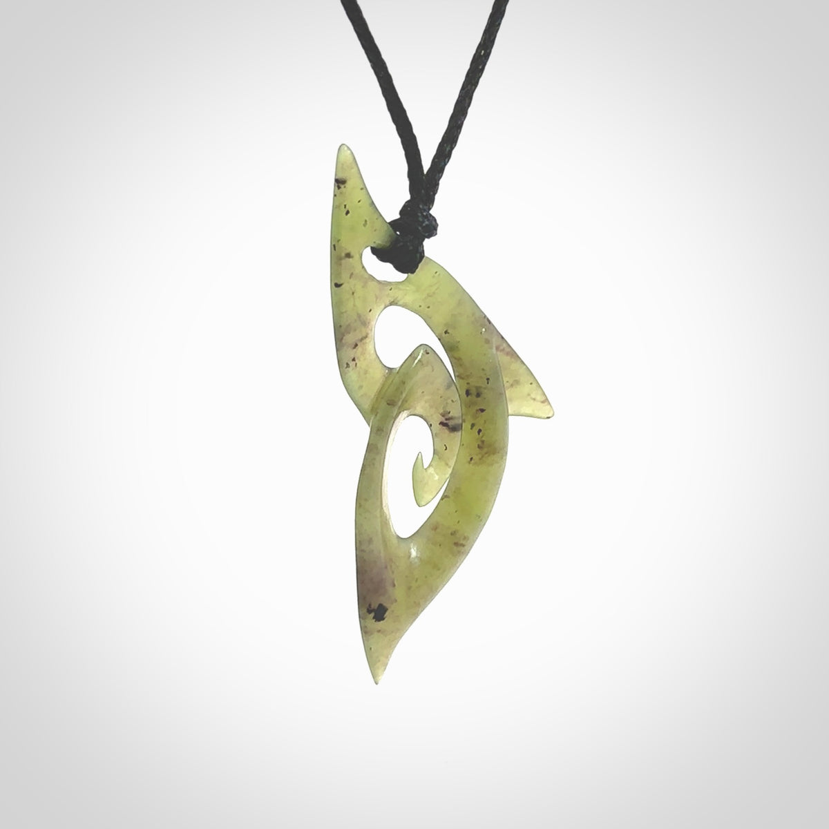 This photo shows a koru pendant carved from New Zealand Jade. The artist, Shaun Gardiner, has carved this beautifully. We provide this piece with an adjustable black cord. This is a fantastic work of art, we have one only.