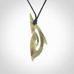 This photo shows a koru pendant carved from New Zealand Jade. The artist, Shaun Gardiner, has carved this beautifully. We provide this piece with an adjustable black cord. This is a fantastic work of art, we have one only.