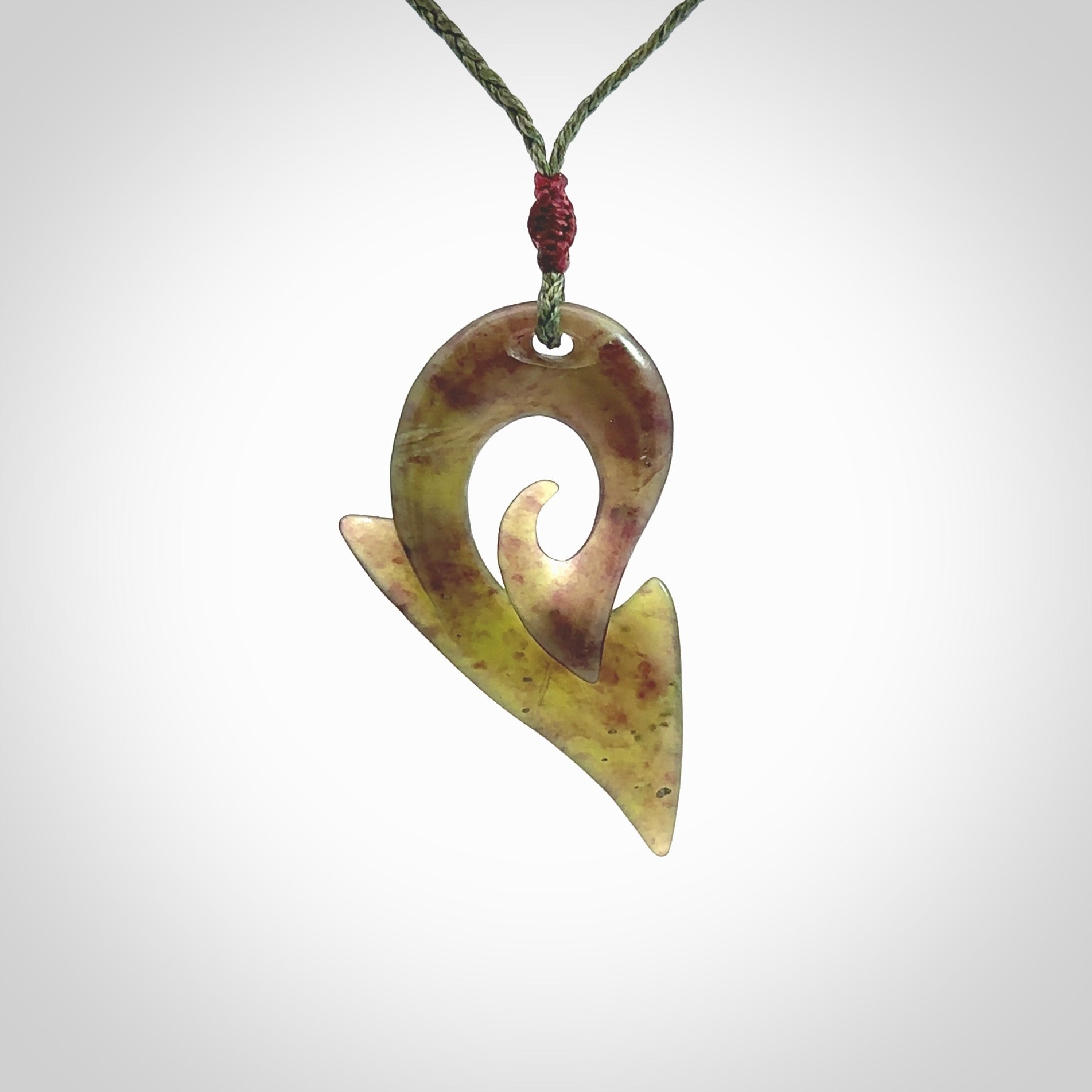 This photo shows a koru pendant carved from New Zealand Jade. The artist, Shaun Gardiner, has carved this beautifully. We provide this piece with an adjustable sage green cord. This is a fantastic work of art, we have one only.