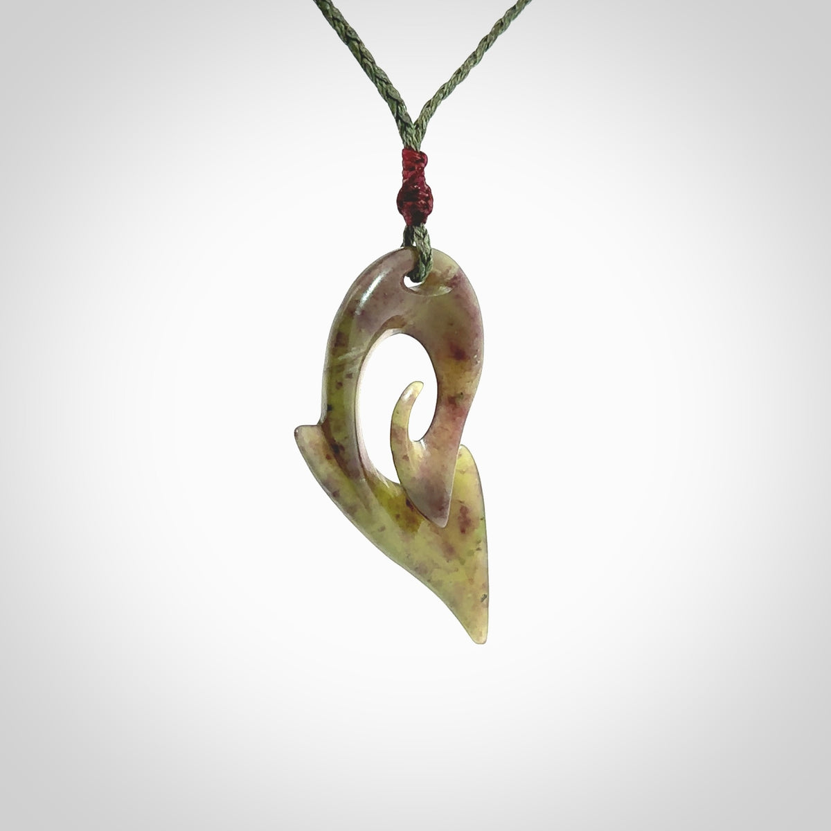 This photo shows a koru pendant carved from New Zealand Jade. The artist, Shaun Gardiner, has carved this beautifully. We provide this piece with an adjustable sage green cord. This is a fantastic work of art, we have one only.