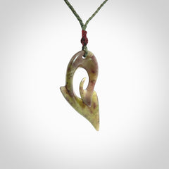 This photo shows a koru pendant carved from New Zealand Jade. The artist, Shaun Gardiner, has carved this beautifully. We provide this piece with an adjustable sage green cord. This is a fantastic work of art, we have one only.