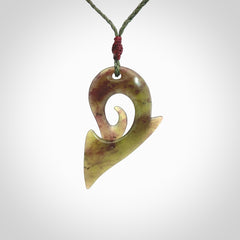 This photo shows a koru pendant carved from New Zealand Jade. The artist, Shaun Gardiner, has carved this beautifully. We provide this piece with an adjustable sage green cord. This is a fantastic work of art, we have one only.