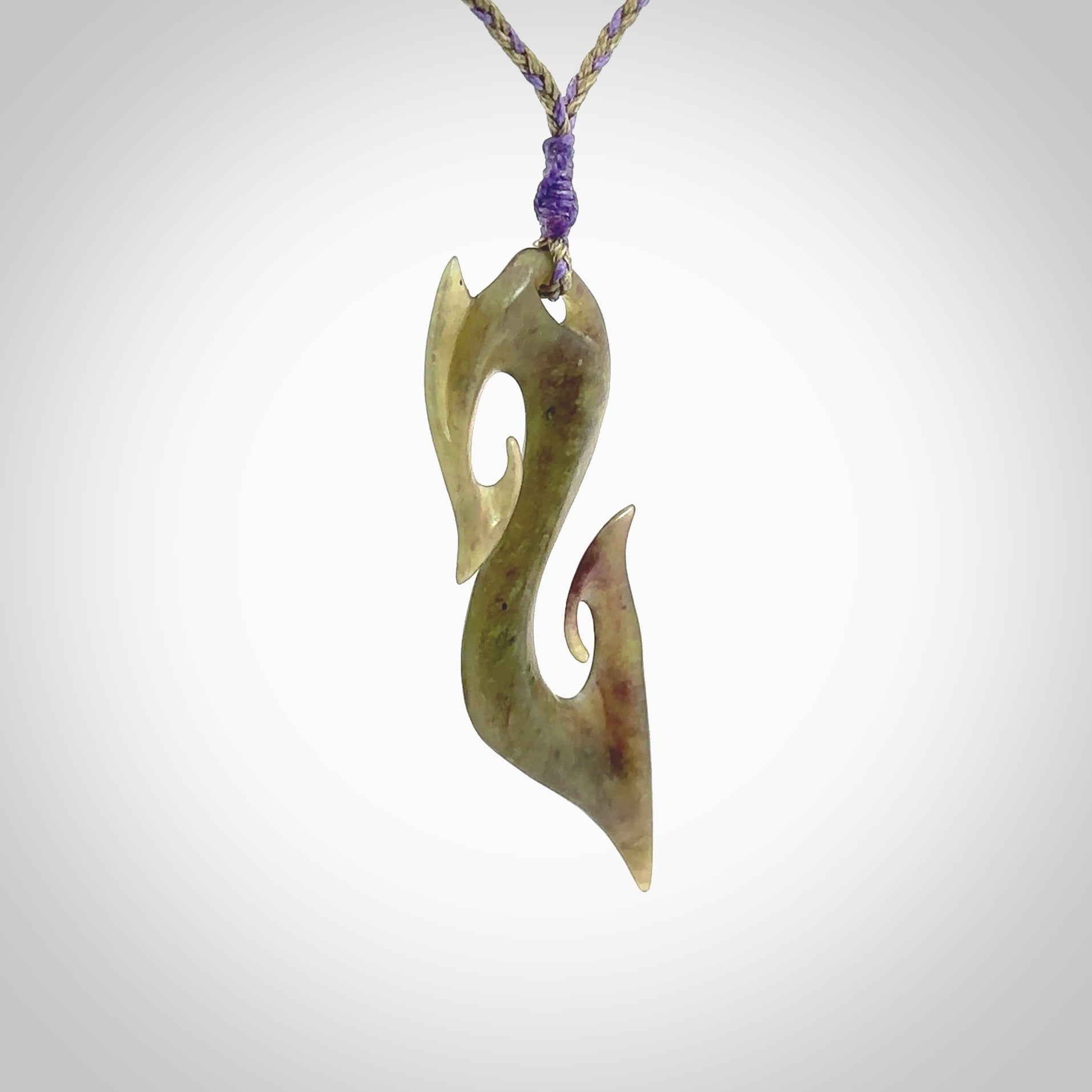 This photo shows a koru pendant carved from New Zealand Jade. The artist, Shaun Gardiner, has carved this beautifully. We provide this piece with an adjustable safari green/lilac cord. This is a fantastic work of art, we have one only.