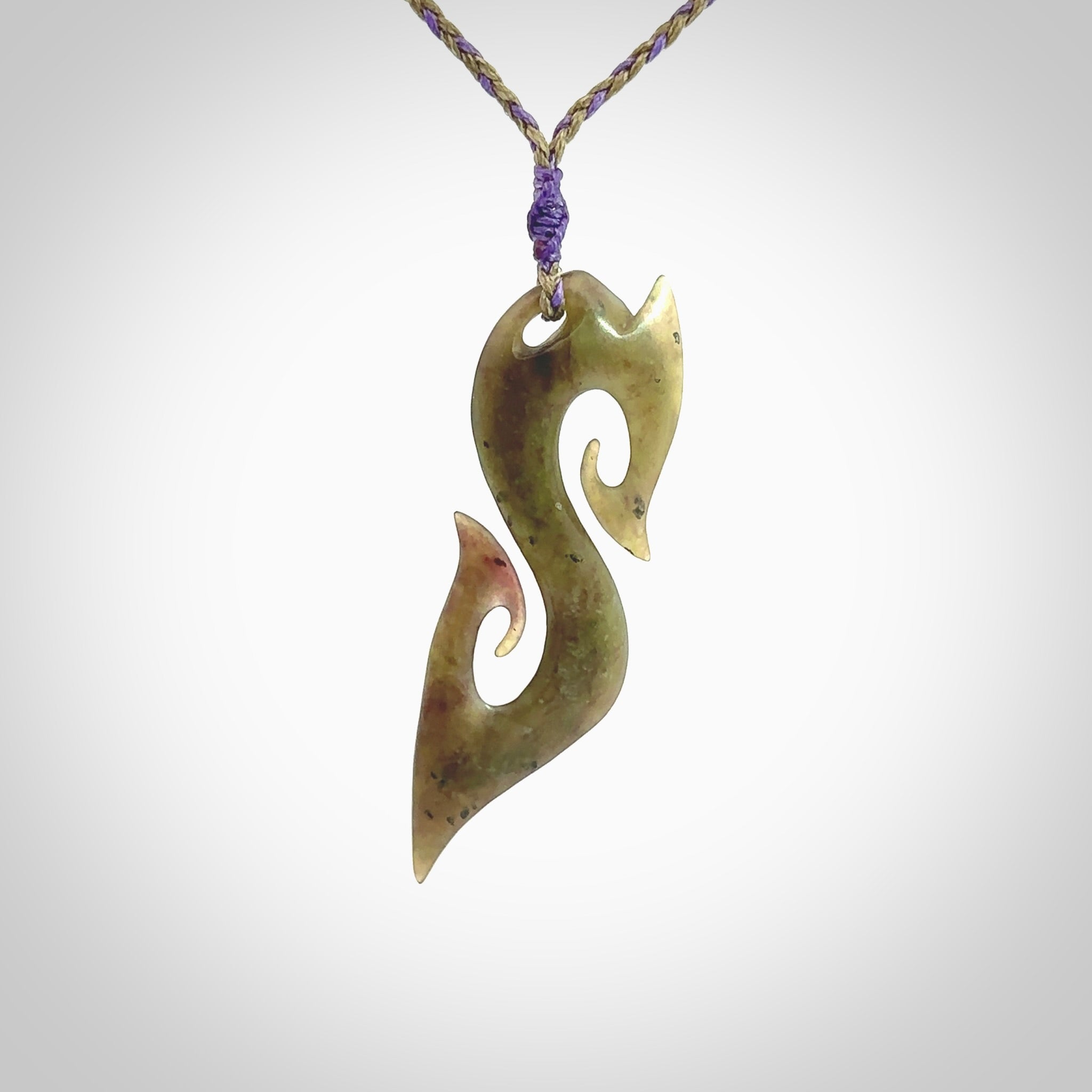 This photo shows a koru pendant carved from New Zealand Jade. The artist, Shaun Gardiner, has carved this beautifully. We provide this piece with an adjustable safari green/lilac cord. This is a fantastic work of art, we have one only.