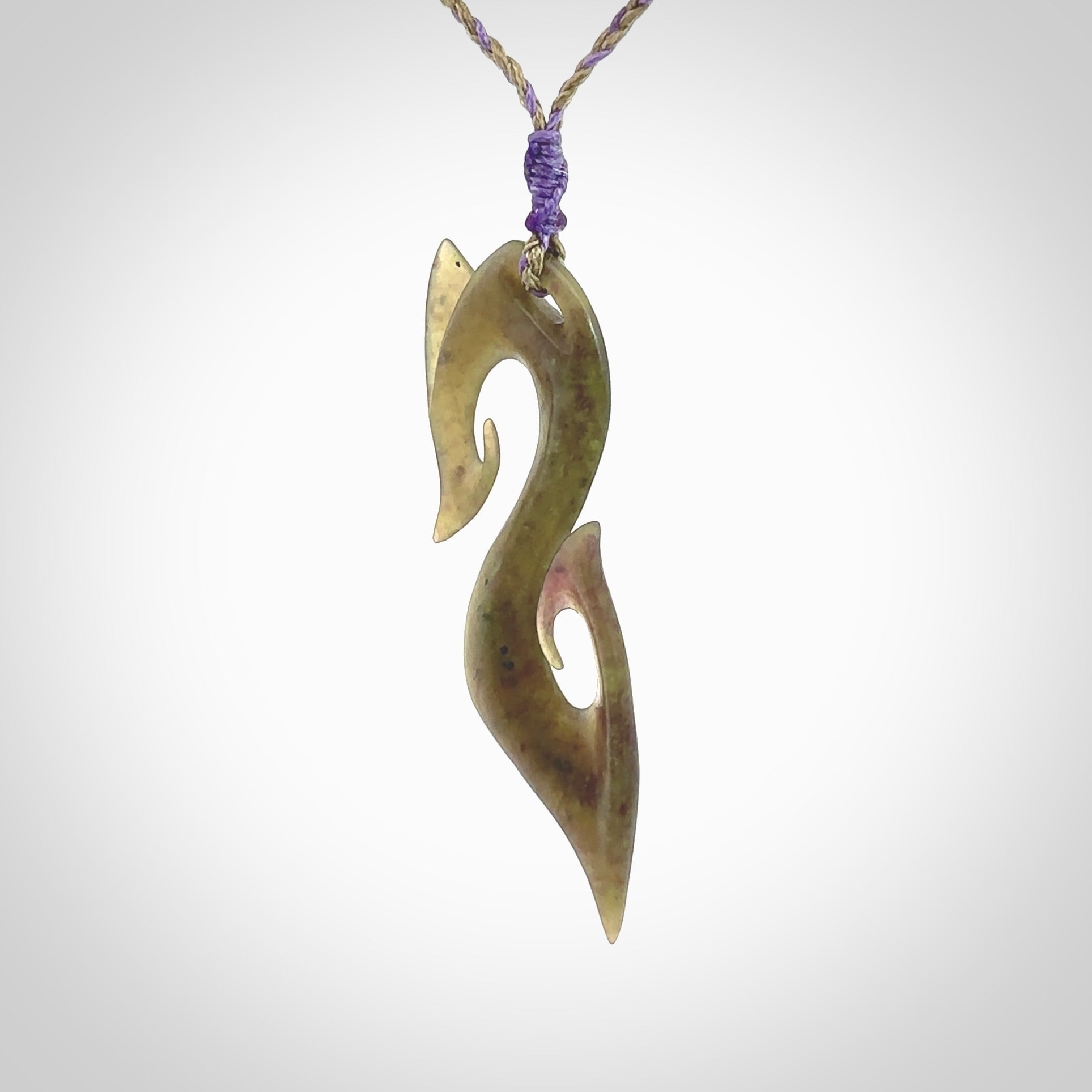 This photo shows a koru pendant carved from New Zealand Jade. The artist, Shaun Gardiner, has carved this beautifully. We provide this piece with an adjustable safari green/lilac cord. This is a fantastic work of art, we have one only.