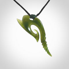 This photo shows a contemporary koru pendant carved from New Zealand Jade. The artist, Shaun Gardiner, has carved this beautifully. We provide this piece with an adjustable black cord. This is a fantastic work of art, we have one only.