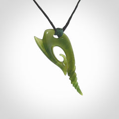 This photo shows a contemporary koru pendant carved from New Zealand Jade. The artist, Shaun Gardiner, has carved this beautifully. We provide this piece with an adjustable black cord. This is a fantastic work of art, we have one only.