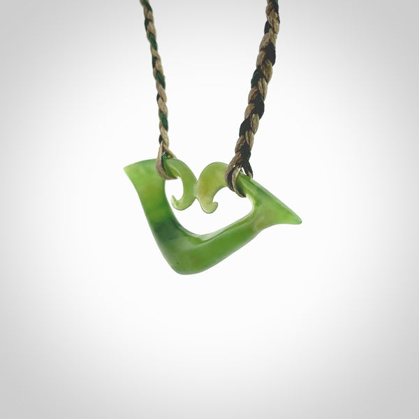 This photo shows a koru pendant carved from New Zealand Jade. The artist, Shaun Gardiner, has carved this beautifully. We provide this piece with a fixed length cord in a two toned green colour. This is a fantastic work of art, we have one only.