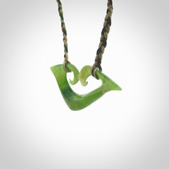 This photo shows a koru pendant carved from New Zealand Jade. The artist, Shaun Gardiner, has carved this beautifully. We provide this piece with a fixed length cord in a two toned green colour. This is a fantastic work of art, we have one only.