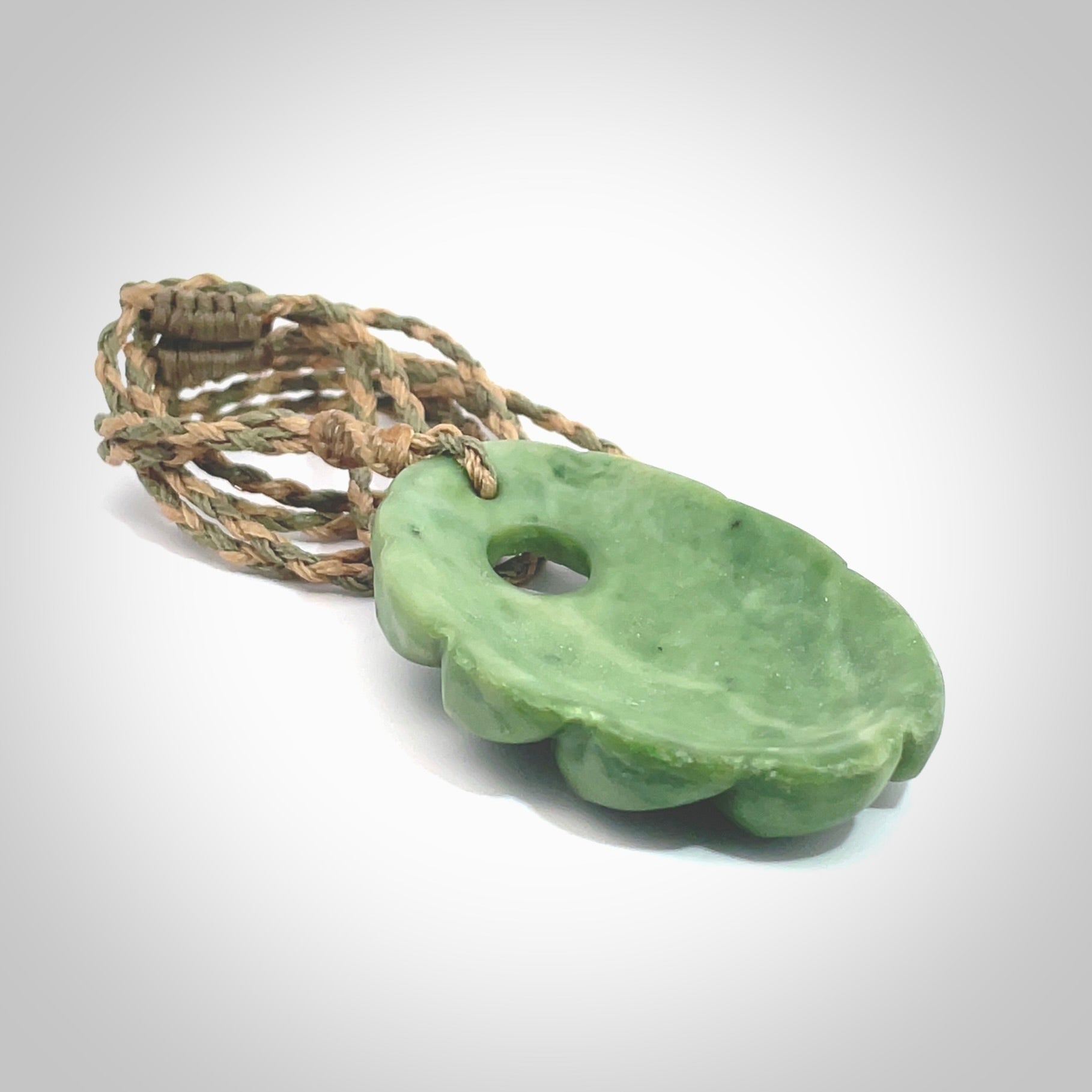 This picture shows a contemporary drop shaped pendant, hand carved from New Zealand flower jade. We will provide this with an adjustable plaited cord. Hand crafted stunning New Zealand Marsden Flower Jade drop pendant by Ana Krakosky.