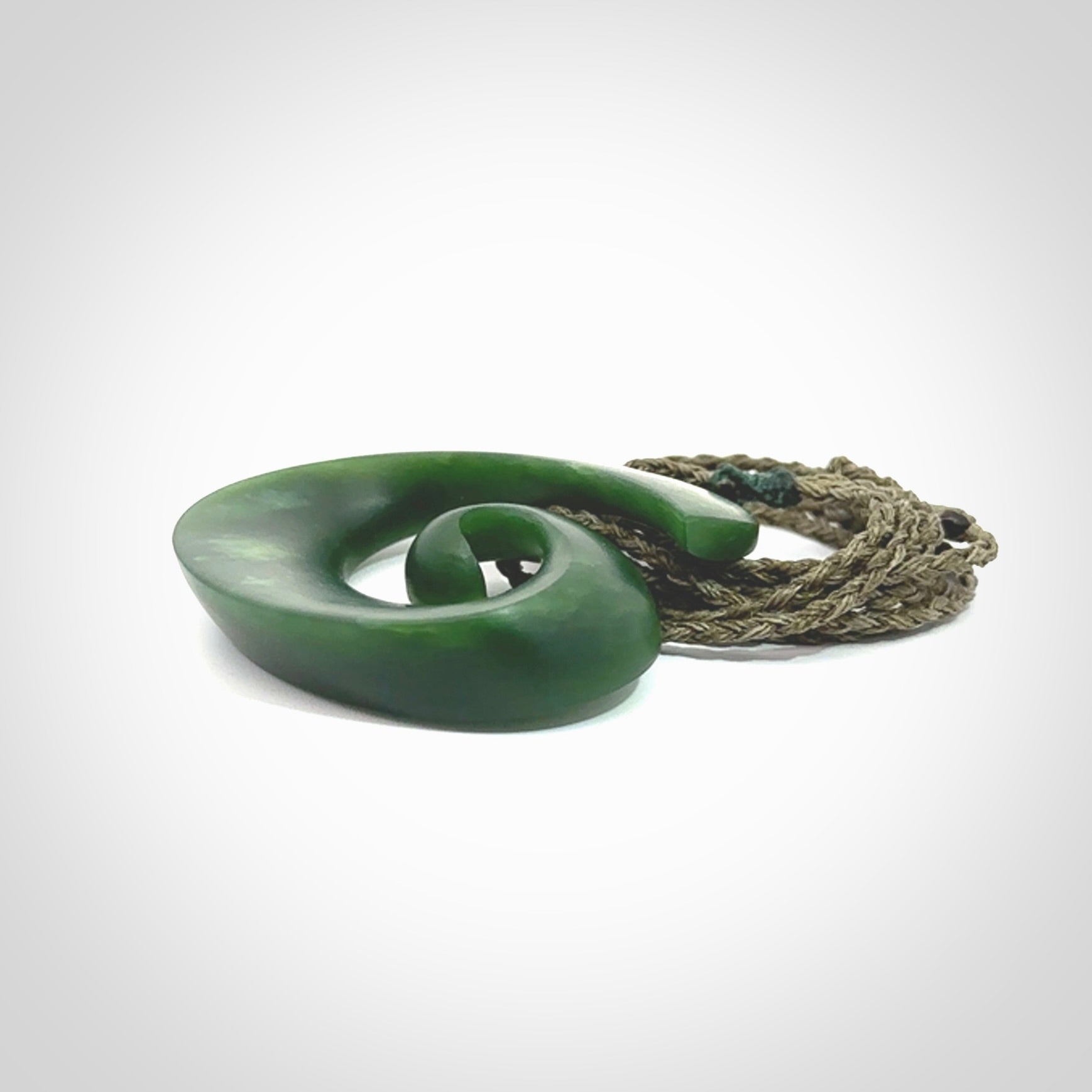 A hand carved koru pendant from New Zealand Jade. The cord is a green colour and is an adjustable length. A large hand made Koru necklace by New Zealand artist Kerry Thompson.