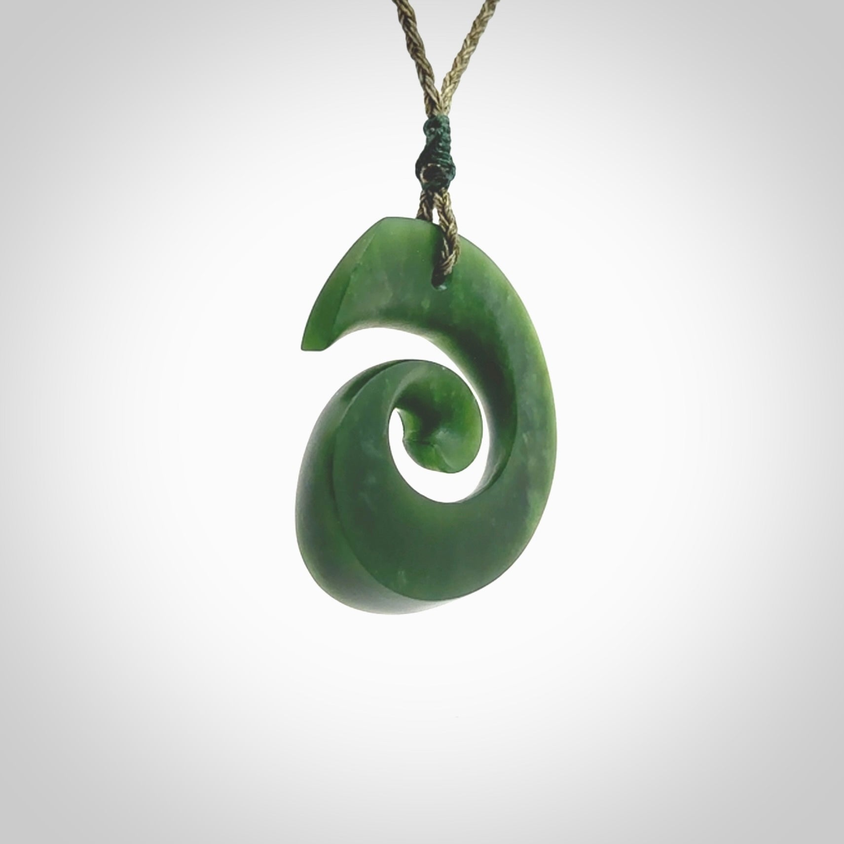 A hand carved koru pendant from New Zealand Jade. The cord is a green colour and is an adjustable length. A large hand made Koru necklace by New Zealand artist Kerry Thompson.