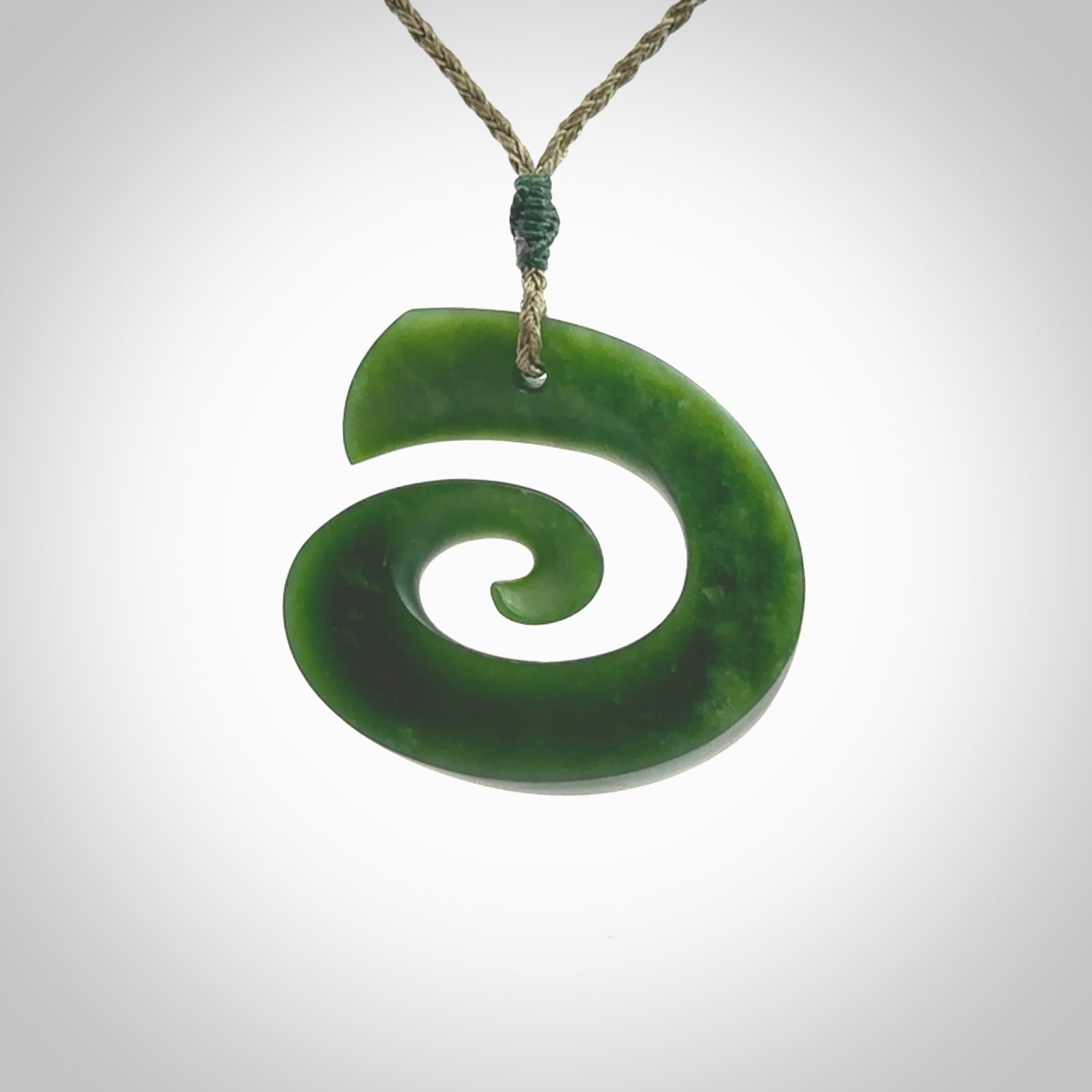 A hand carved koru pendant from New Zealand Jade. The cord is a green colour and is an adjustable length. A large hand made Koru necklace by New Zealand artist Kerry Thompson.