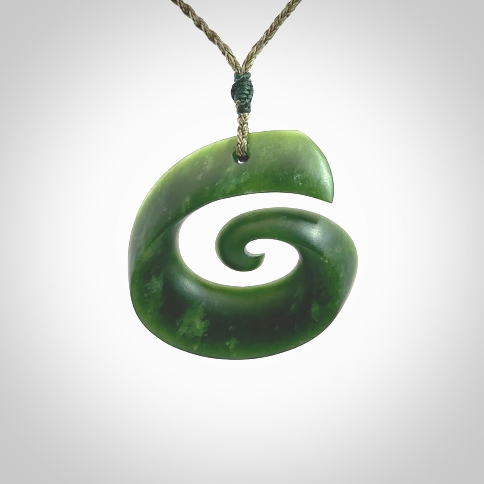 A hand carved koru pendant from New Zealand Jade. The cord is a green colour and is an adjustable length. A large hand made Koru necklace by New Zealand artist Kerry Thompson.