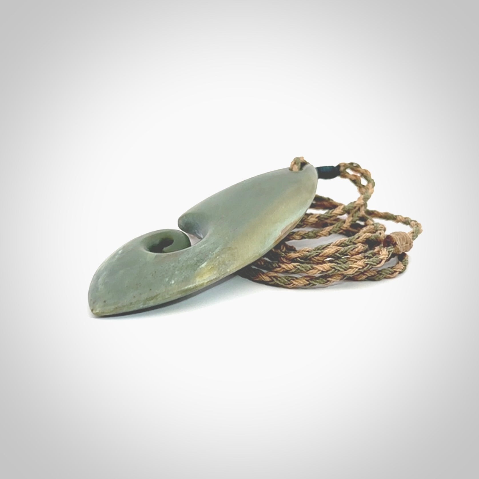 A hand carved koru pendant from New Zealand Inanga Jade. The cord is a tan/khaki colour and is an adjustable length. A large hand made Koru necklace by New Zealand artist Kerry Thompson.