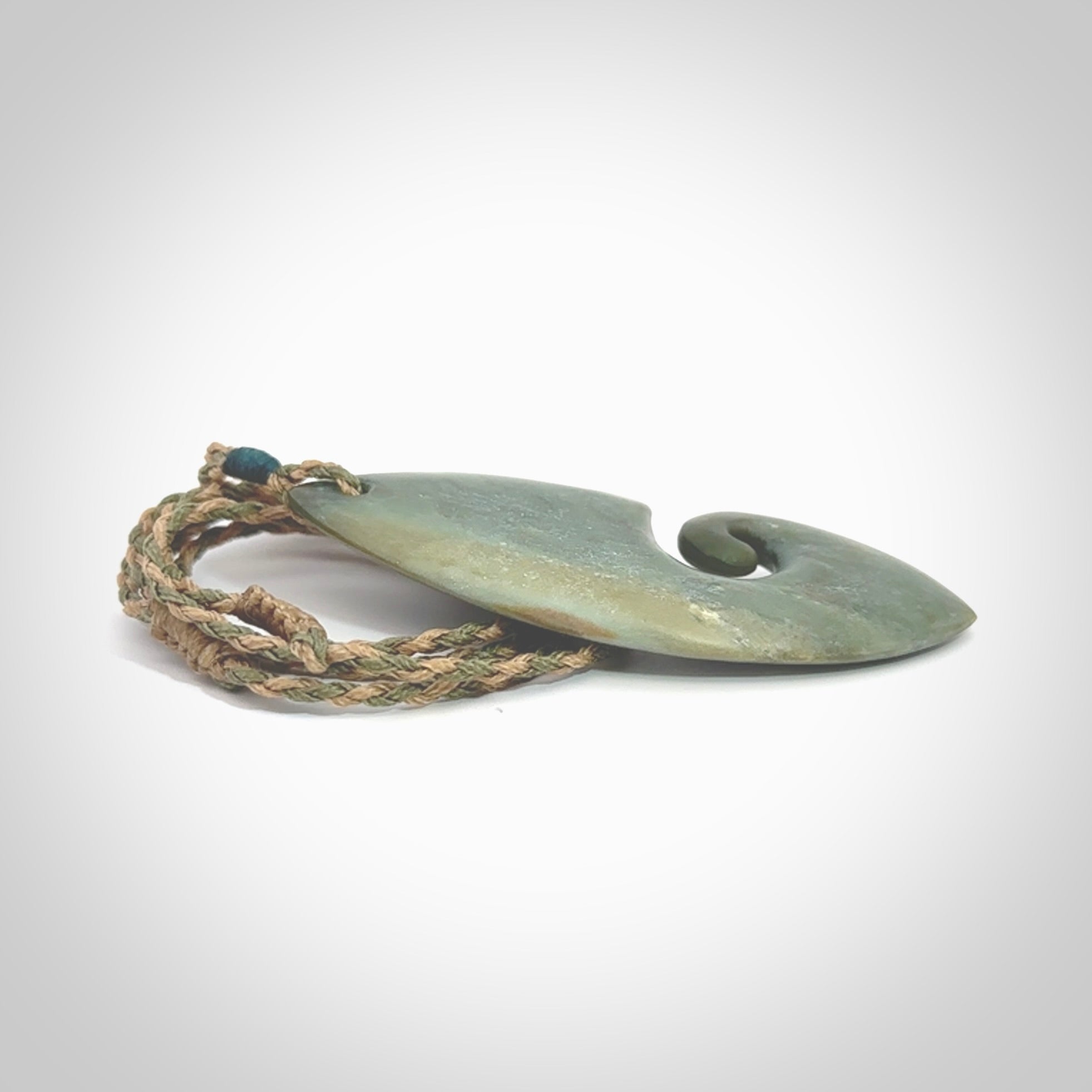 A hand carved koru pendant from New Zealand Inanga Jade. The cord is a tan/khaki colour and is an adjustable length. A large hand made Koru necklace by New Zealand artist Kerry Thompson.