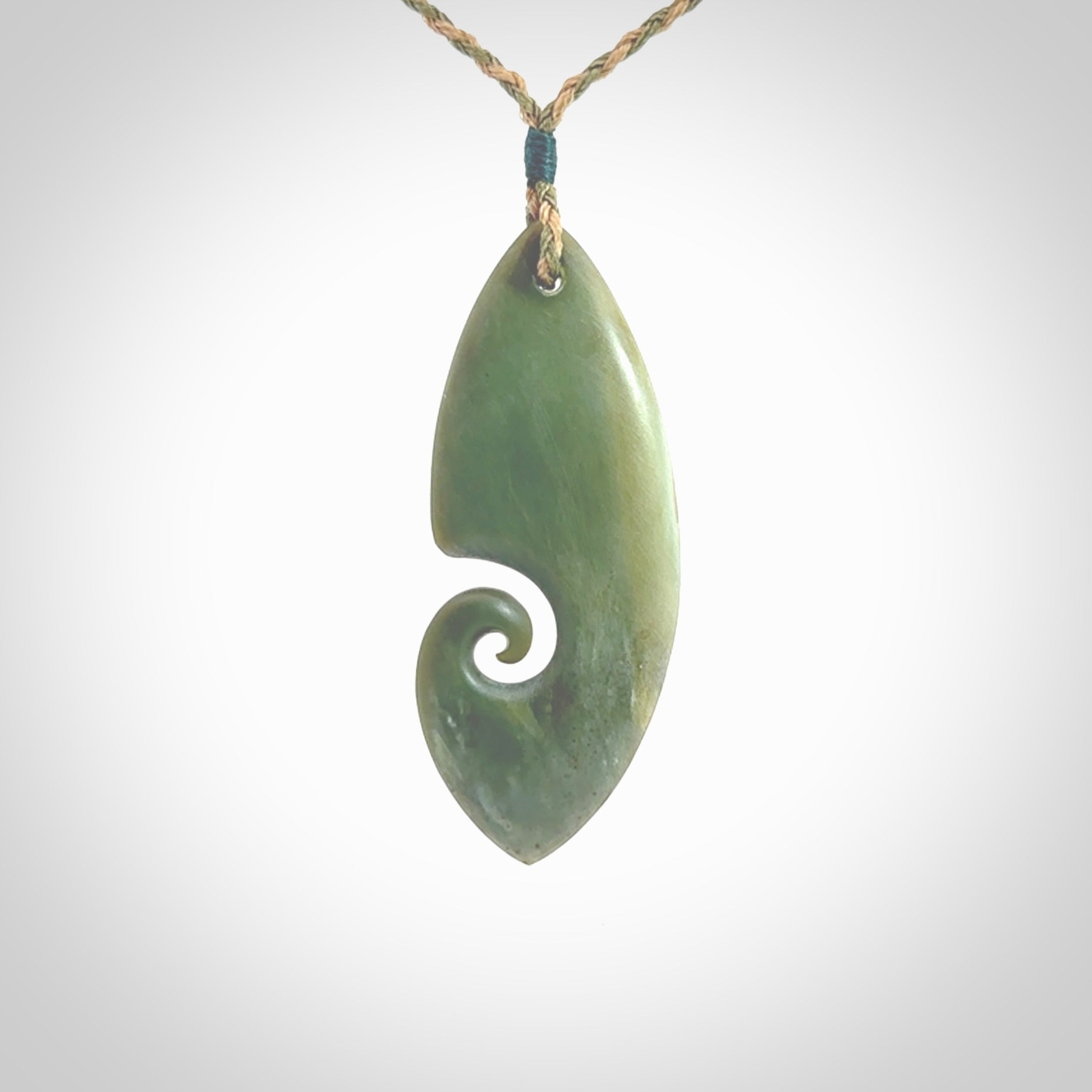 A hand carved koru pendant from New Zealand Inanga Jade. The cord is a tan/khaki colour and is an adjustable length. A large hand made Koru necklace by New Zealand artist Kerry Thompson.