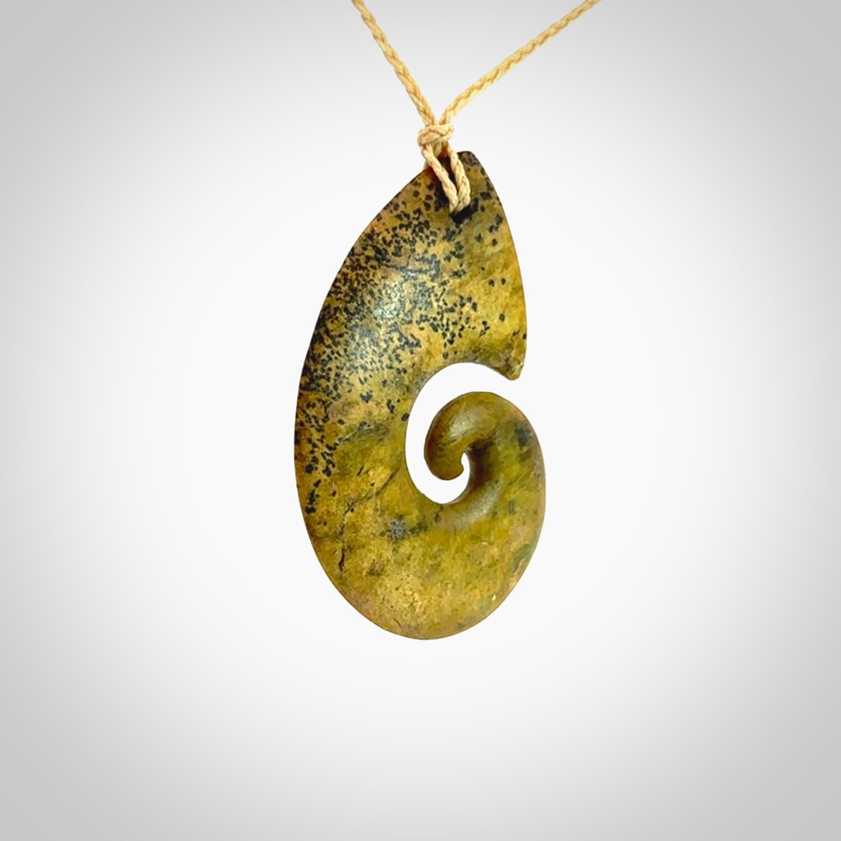 A hand carved koru pendant from New Zealand Flower Jade. The cord is a oat colour and is an adjustable length. A large hand made Koru necklace by New Zealand artist Kerry Thompson.