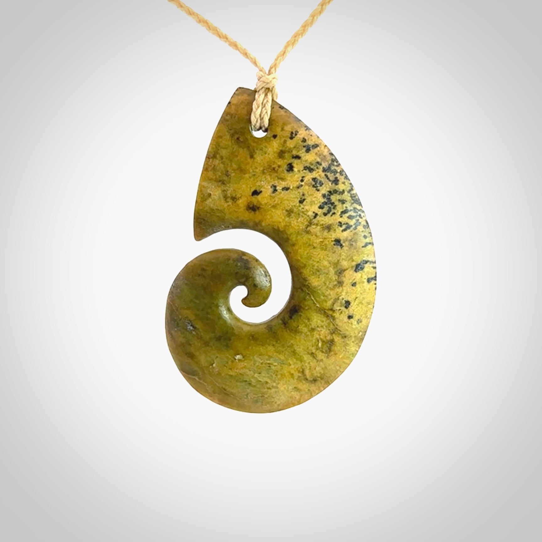 A hand carved koru pendant from New Zealand Flower Jade. The cord is a oat colour and is an adjustable length. A large hand made Koru necklace by New Zealand artist Kerry Thompson.