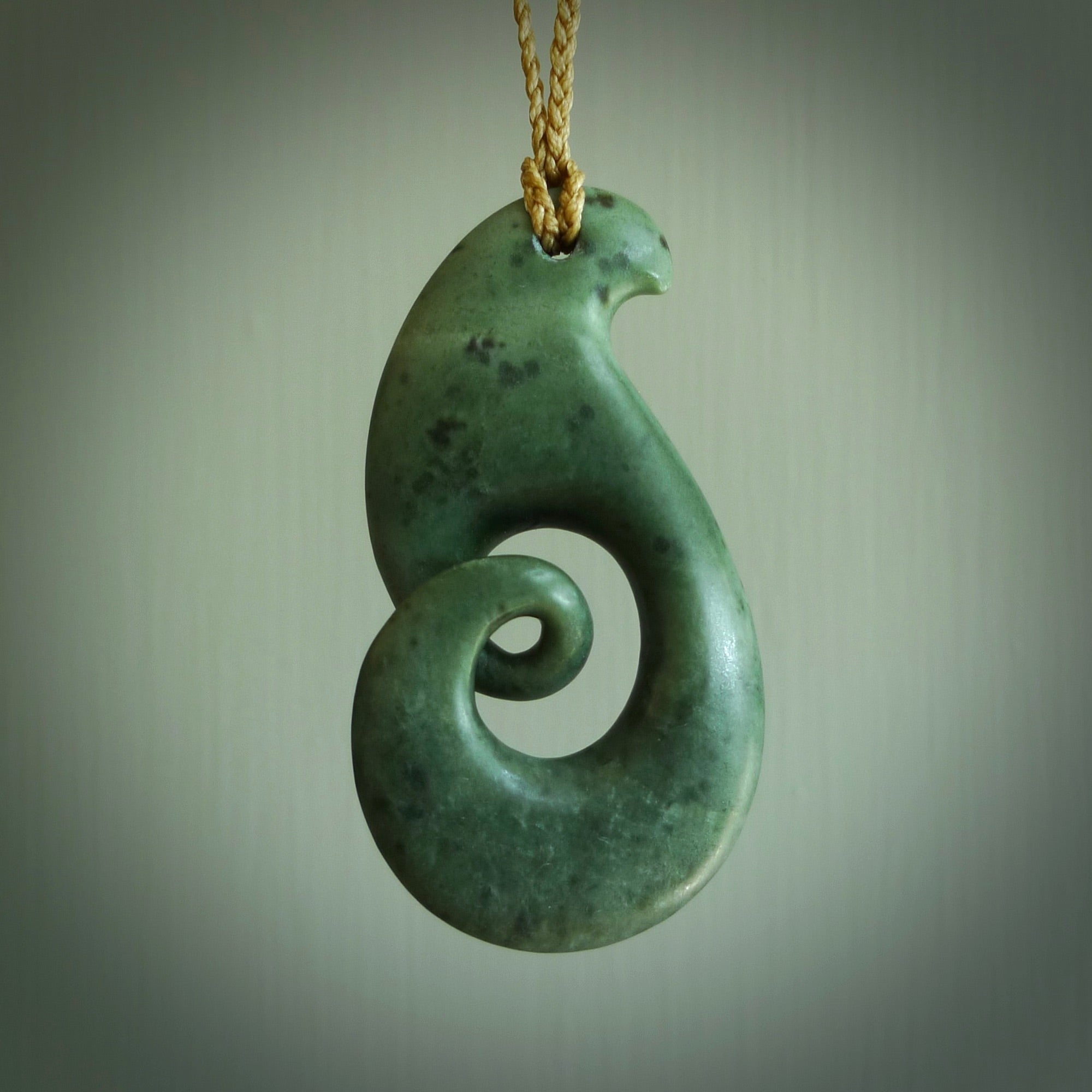 A hand carved koru pendant from New Zealand Jade. The cord is a tan colour and is adjustable. A large hand made Koru necklace by New Zealand artist Kerry Thompson.