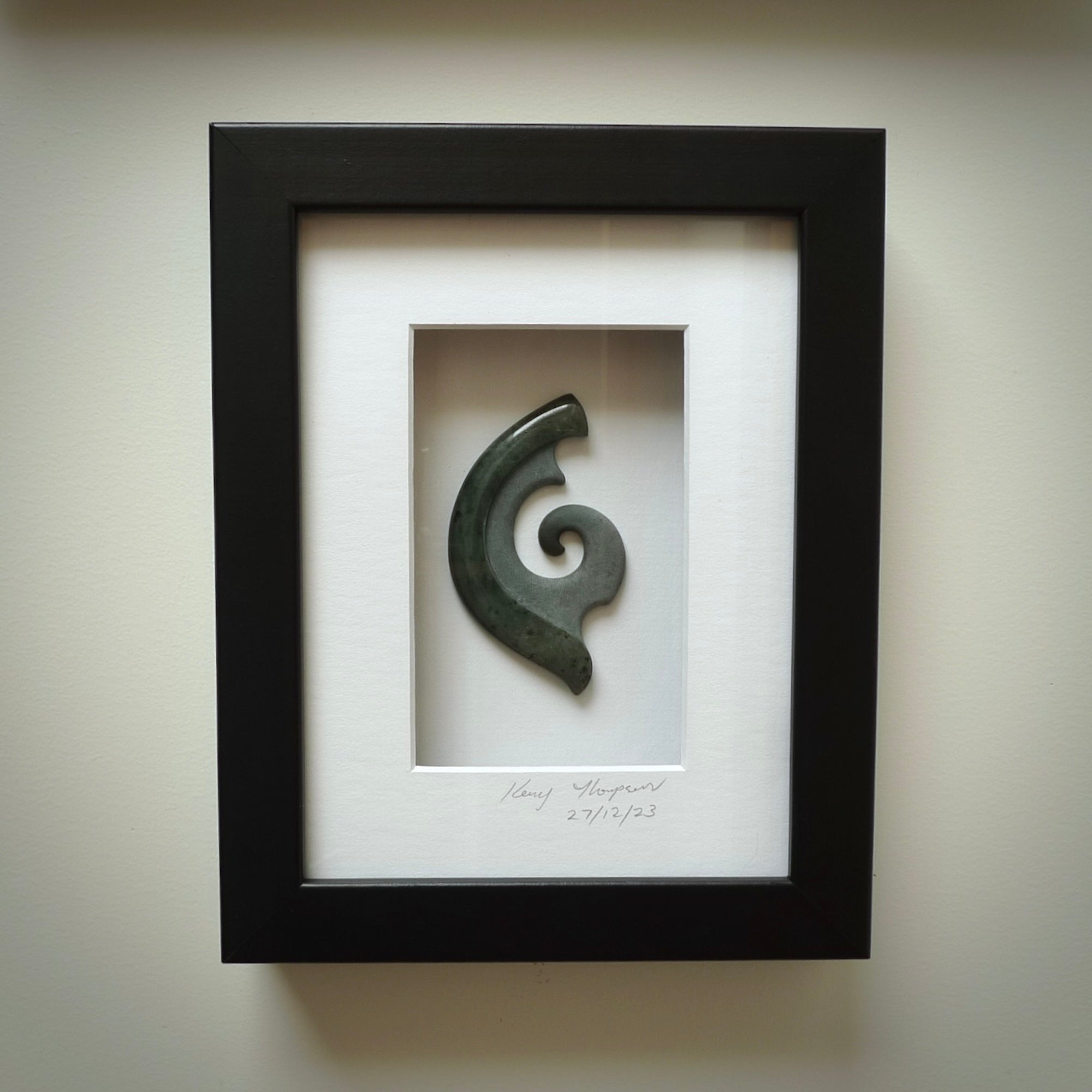 A hand carved large New Zealand Jade Koru necklace that has been framed and signed by artist Kerry Thompson. A large sized hand made koru necklace by New Zealand artist Kerry Thompson. One off framed work of art to wear. Delivered with Express Courier.