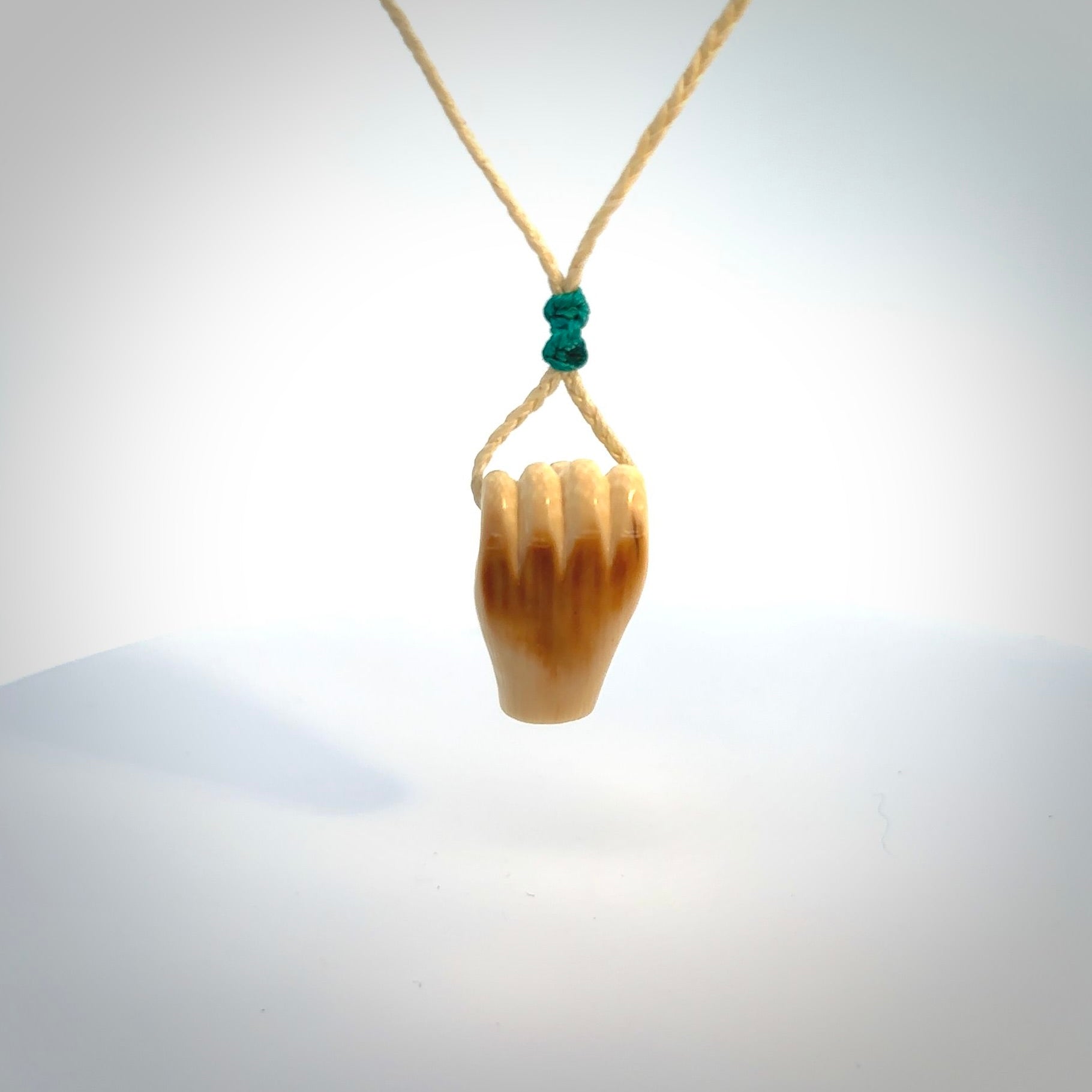 Hand carved pendant symbolising strength and hope - Shown worn. Carved by NZ Pacific from ancient woolly mammoth tusk. Unique jewellery for sale online.