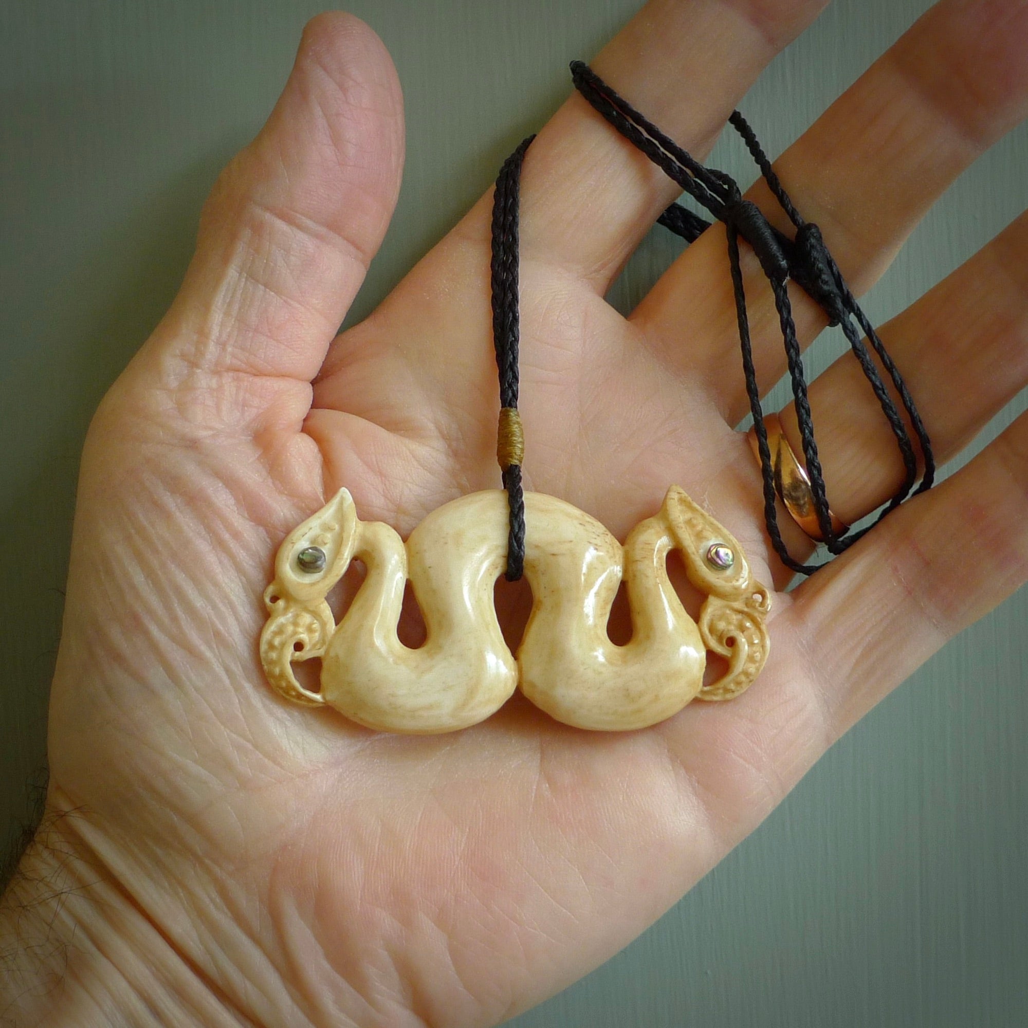 This is a unique double manaia, pekapeka, hand carved bone pendant from cow bone. This is delivered to you with Express Courier. The eyes are made from Paua shell.