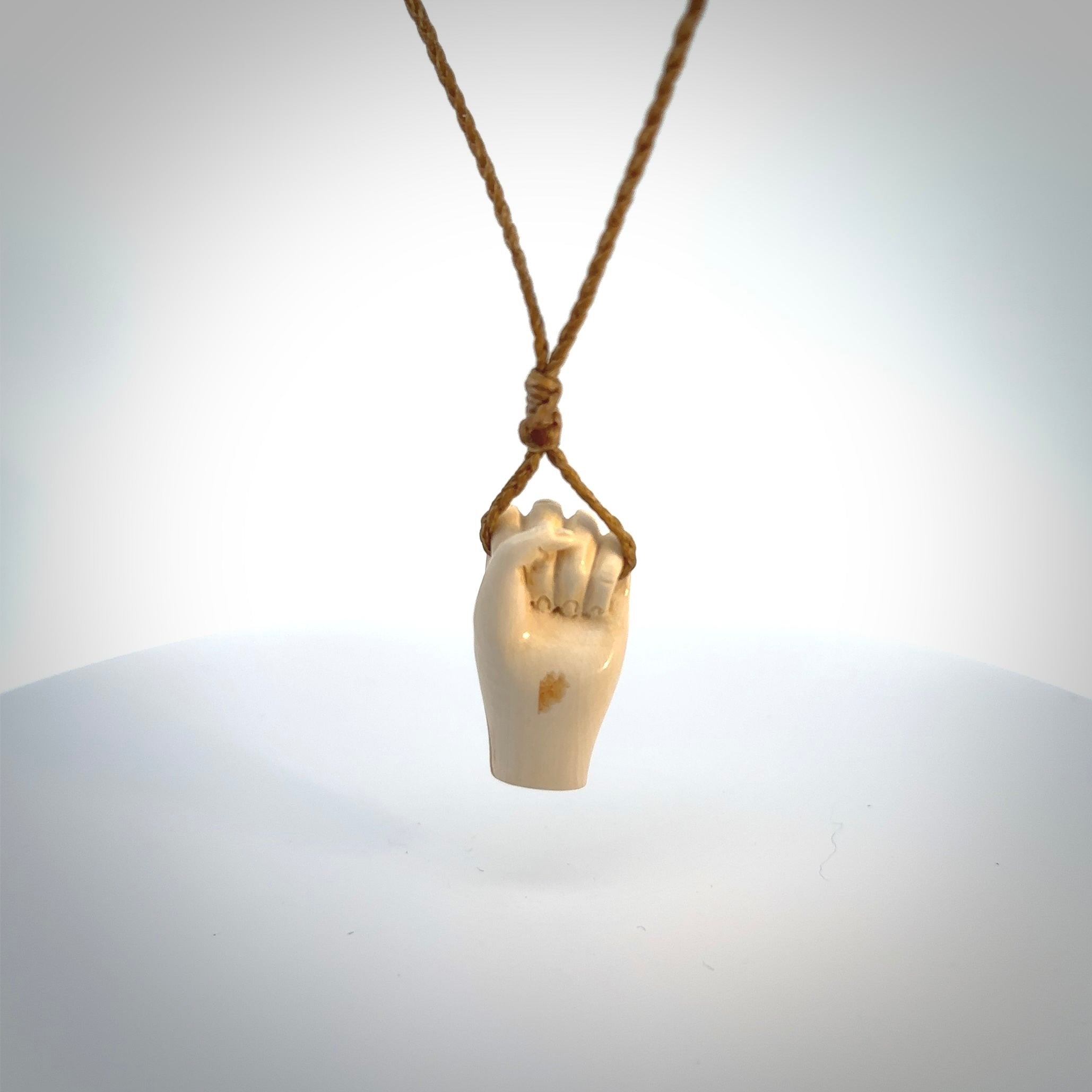 Hand carved pendant symbolising strength and hope - Shown worn. Carved by NZ Pacific from ancient woolly mammoth tusk. Unique jewellery for sale online.